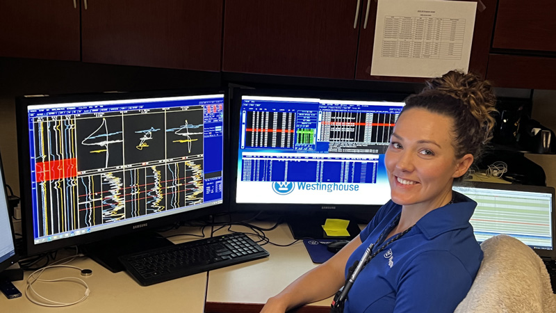 Young engineer checking the system, smiling at camera