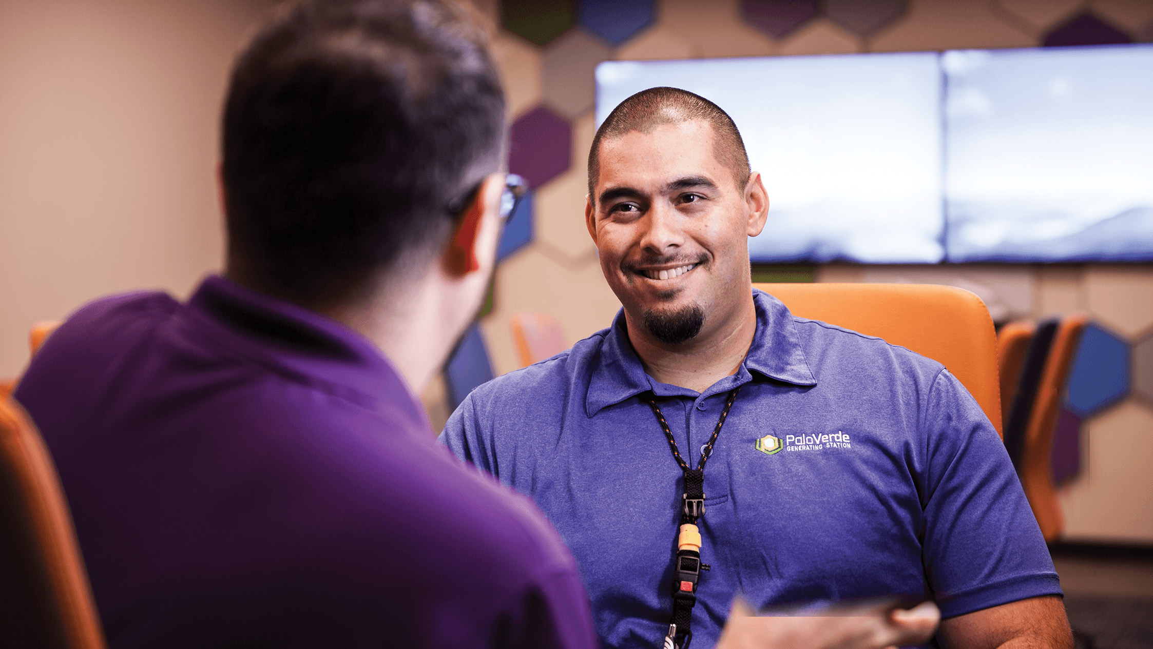 Palo Verde employee smiling and speaking with a co-worker.