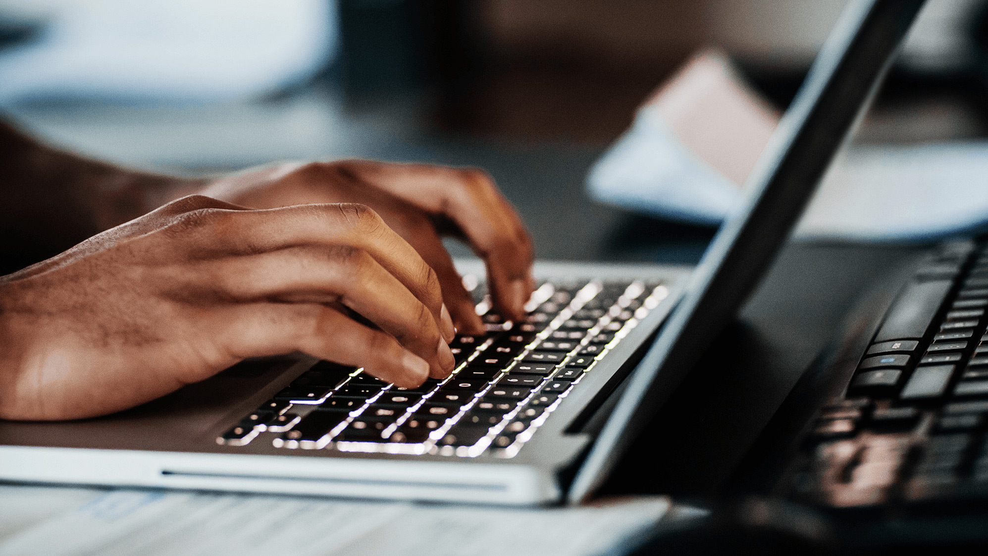 Hands typing on a laptop.