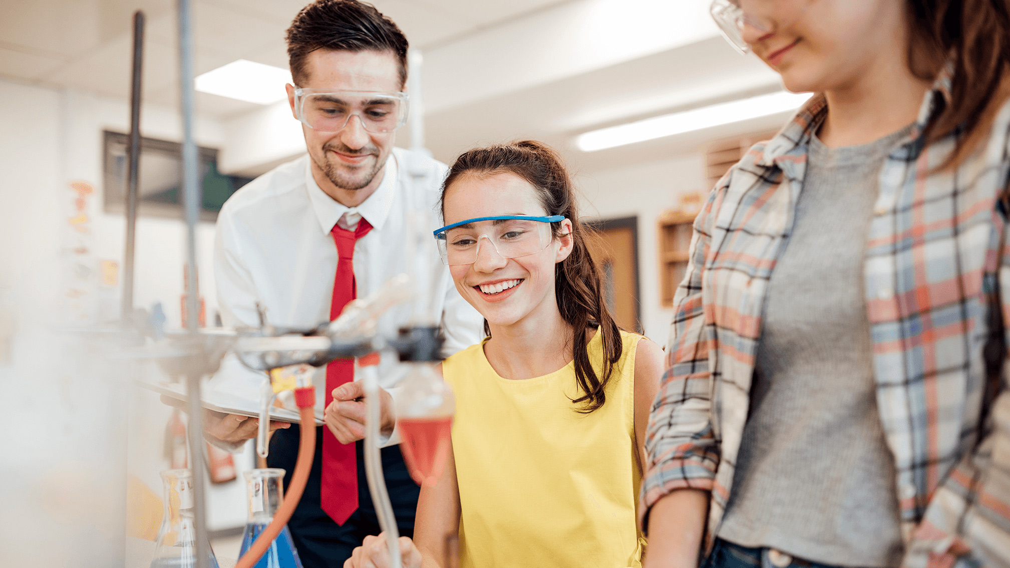 Teacher working with students on a science project.