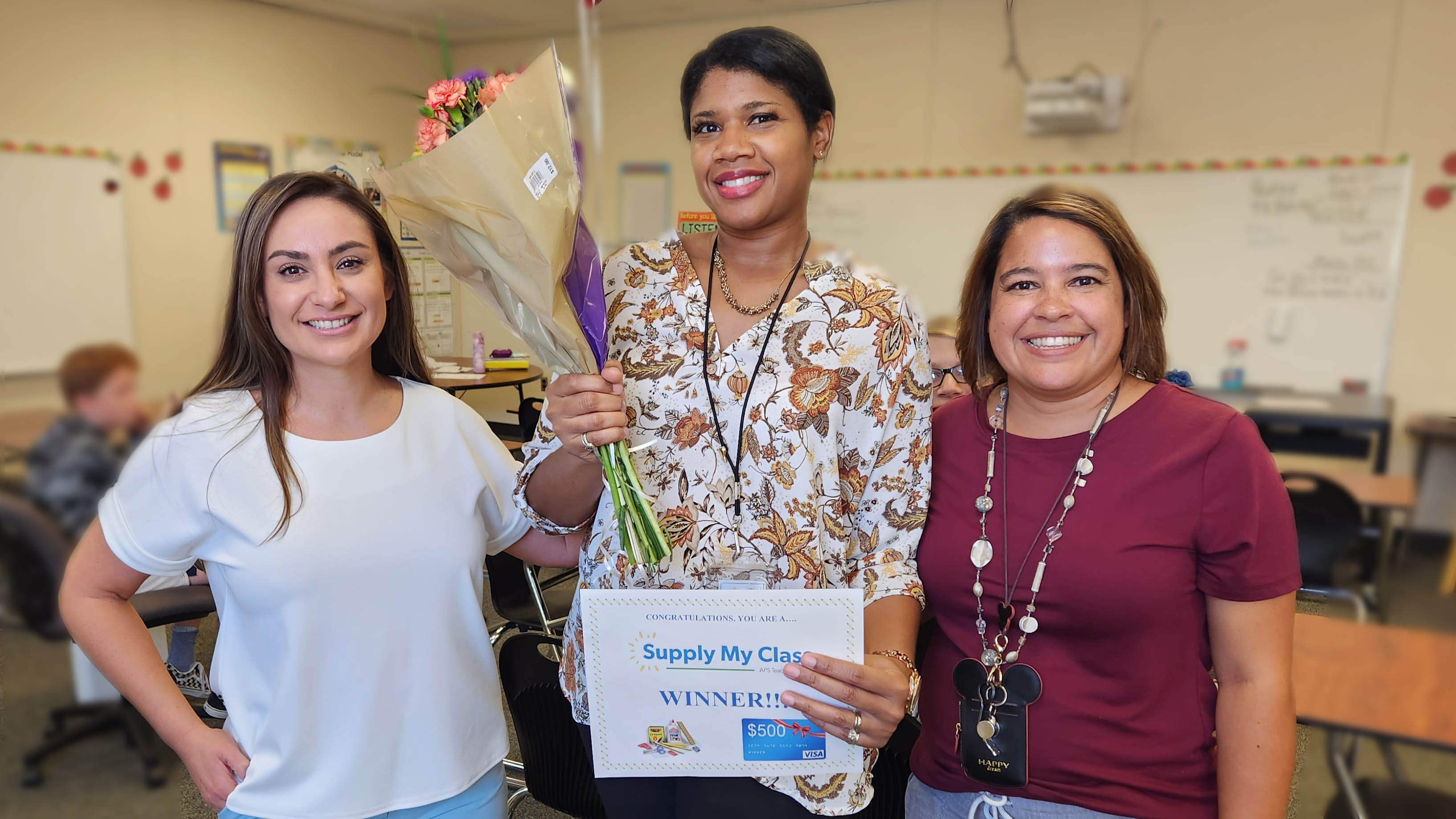 Excited teachers holding congratulatory signs