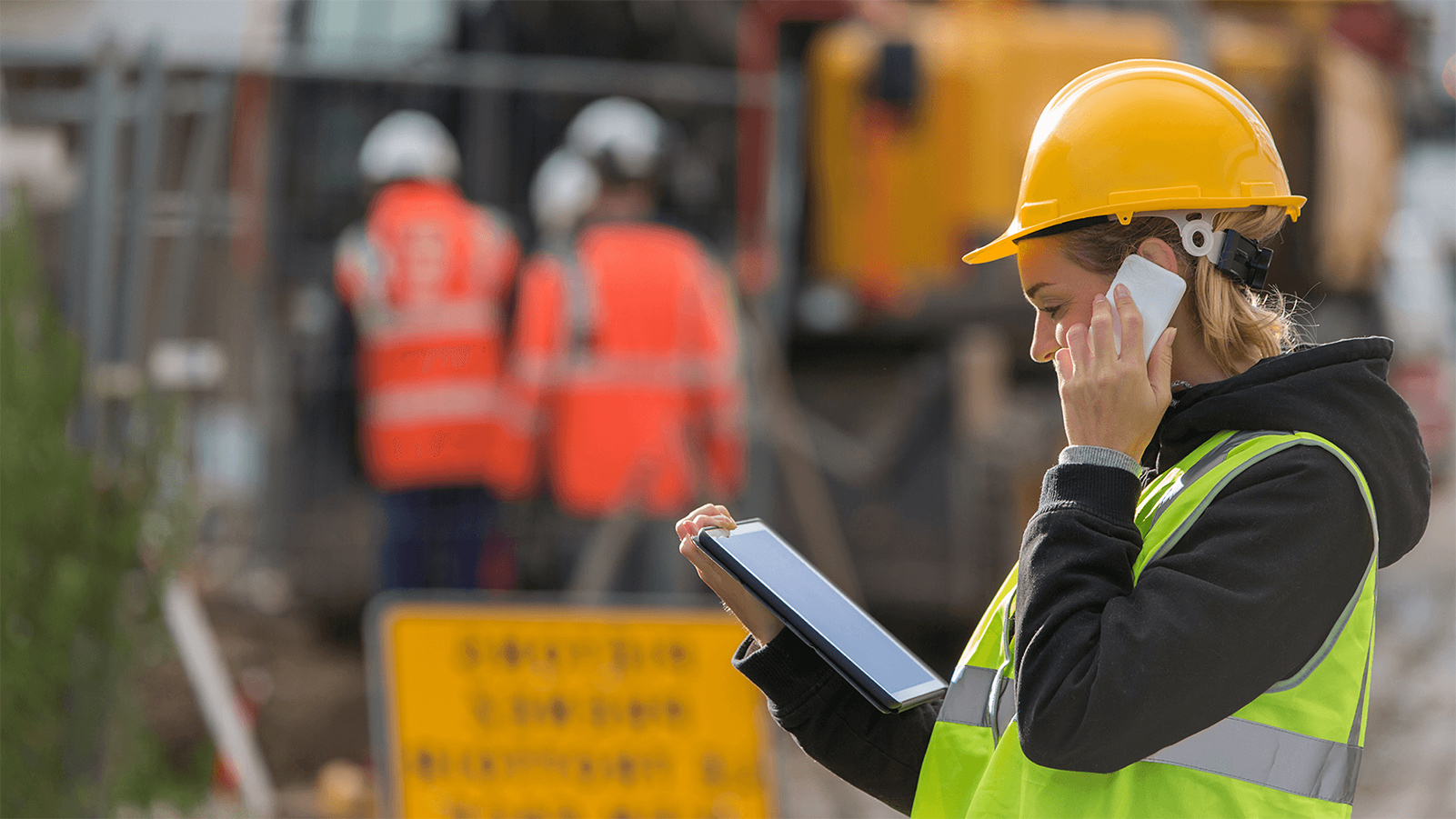 Construction worker talking on her phone at a construction site.