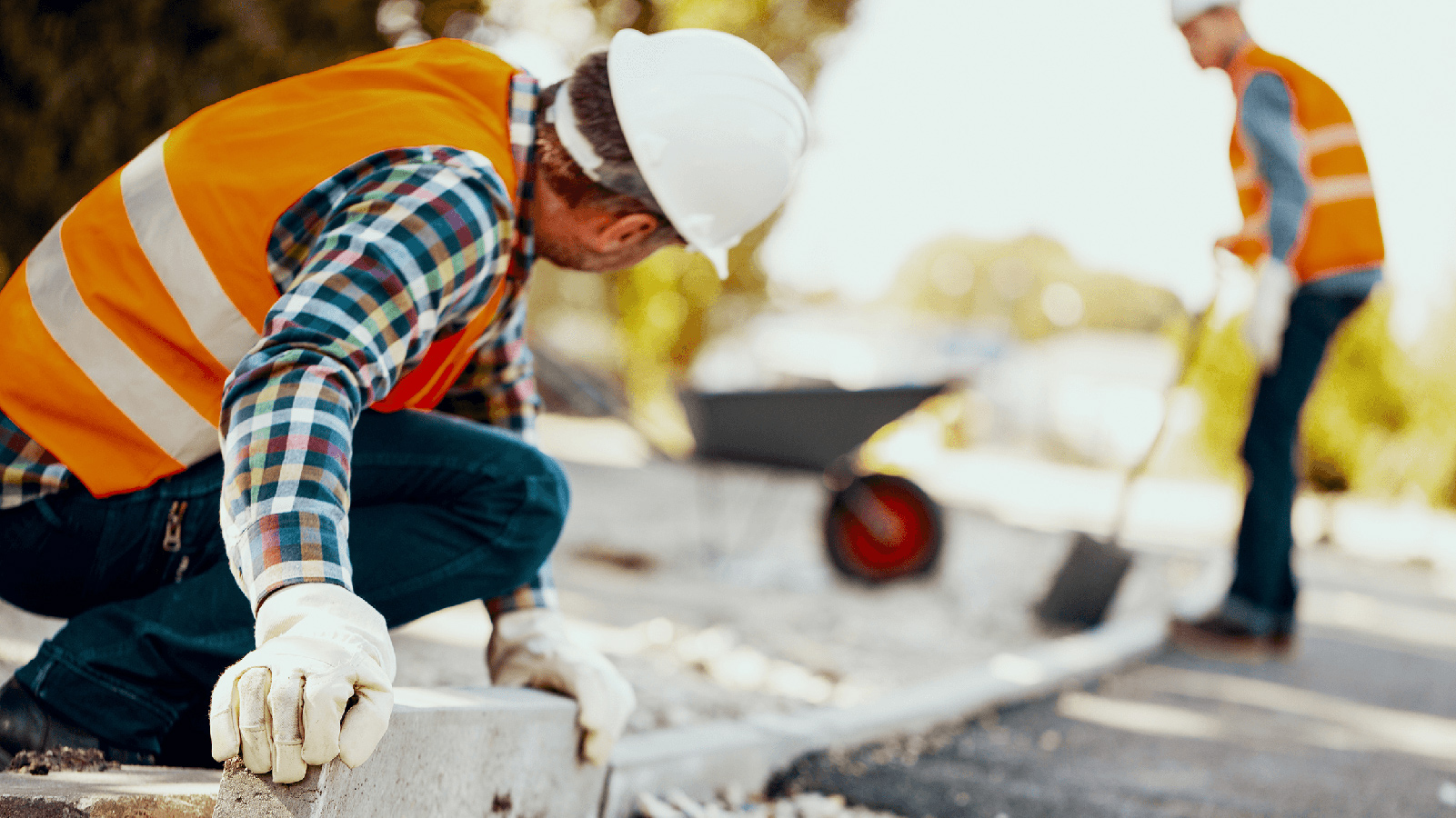 Two construction workers installing a cement boarder.