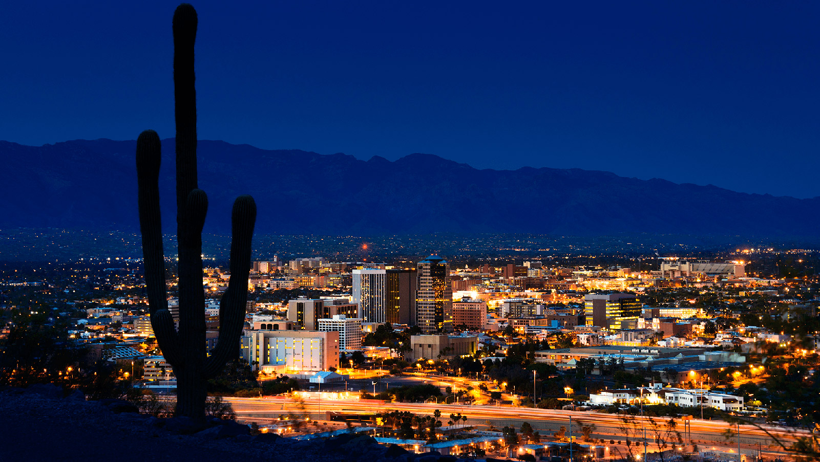 Valley city lit up against a night sky.