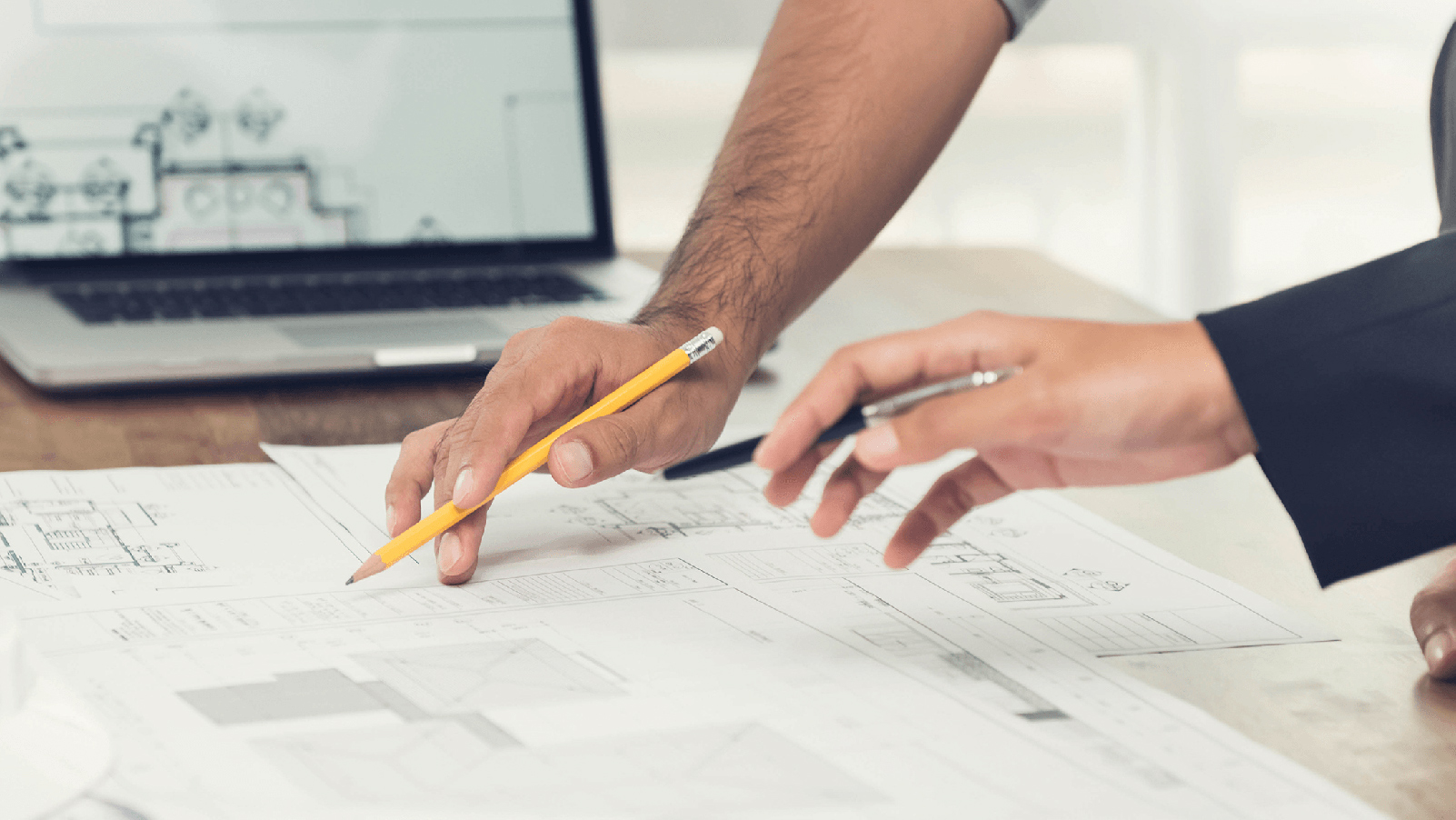 Two people working on blueprints.