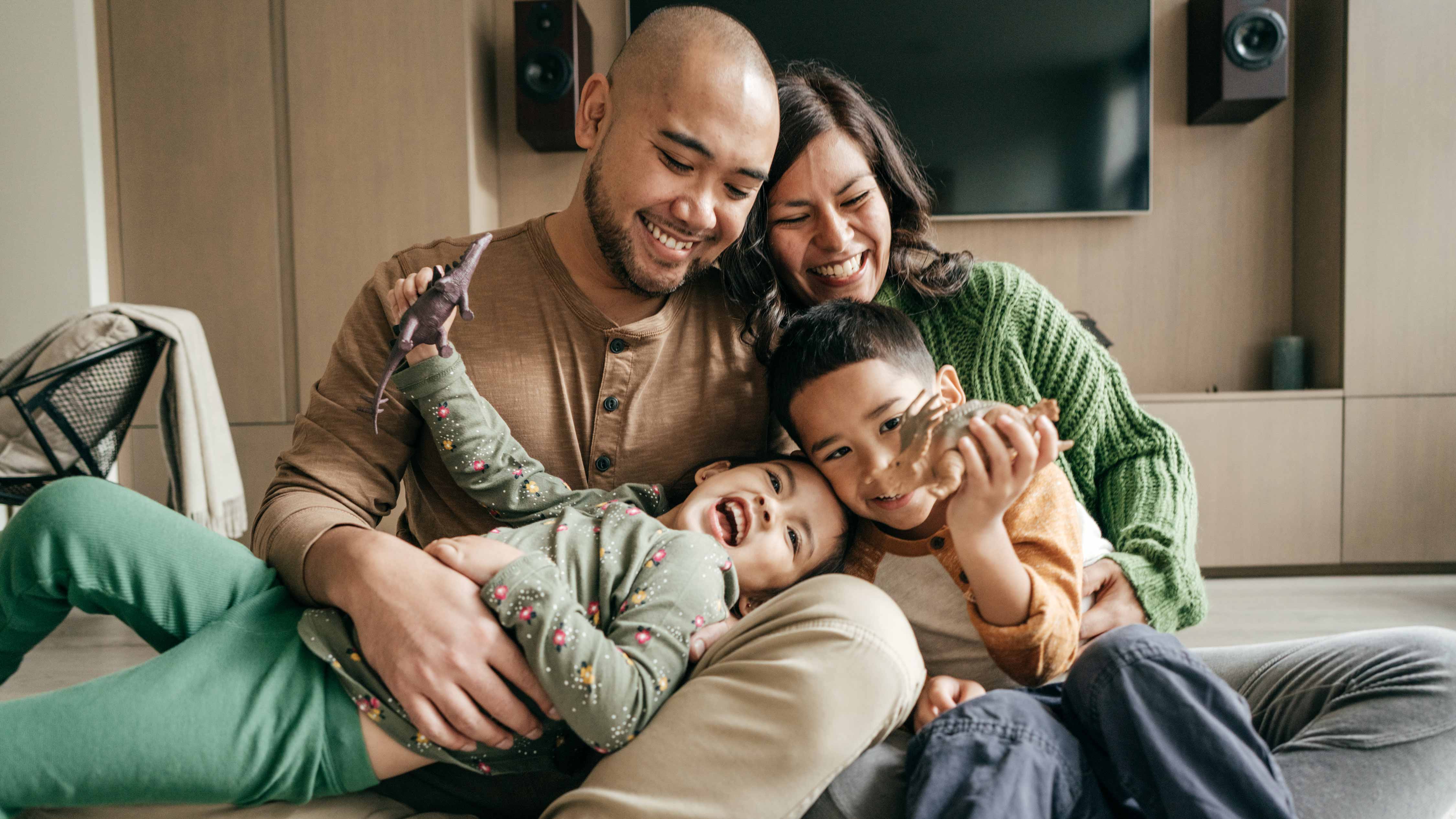 parents playing with young children inside 