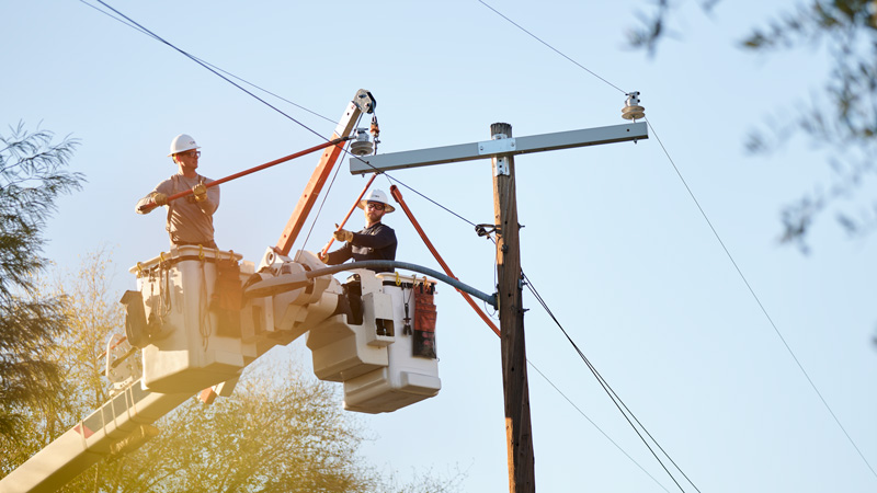 Linemen in a bucket working on a power line