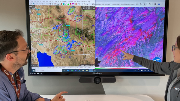 APS meteorologists at a screen monitoring weather patterns