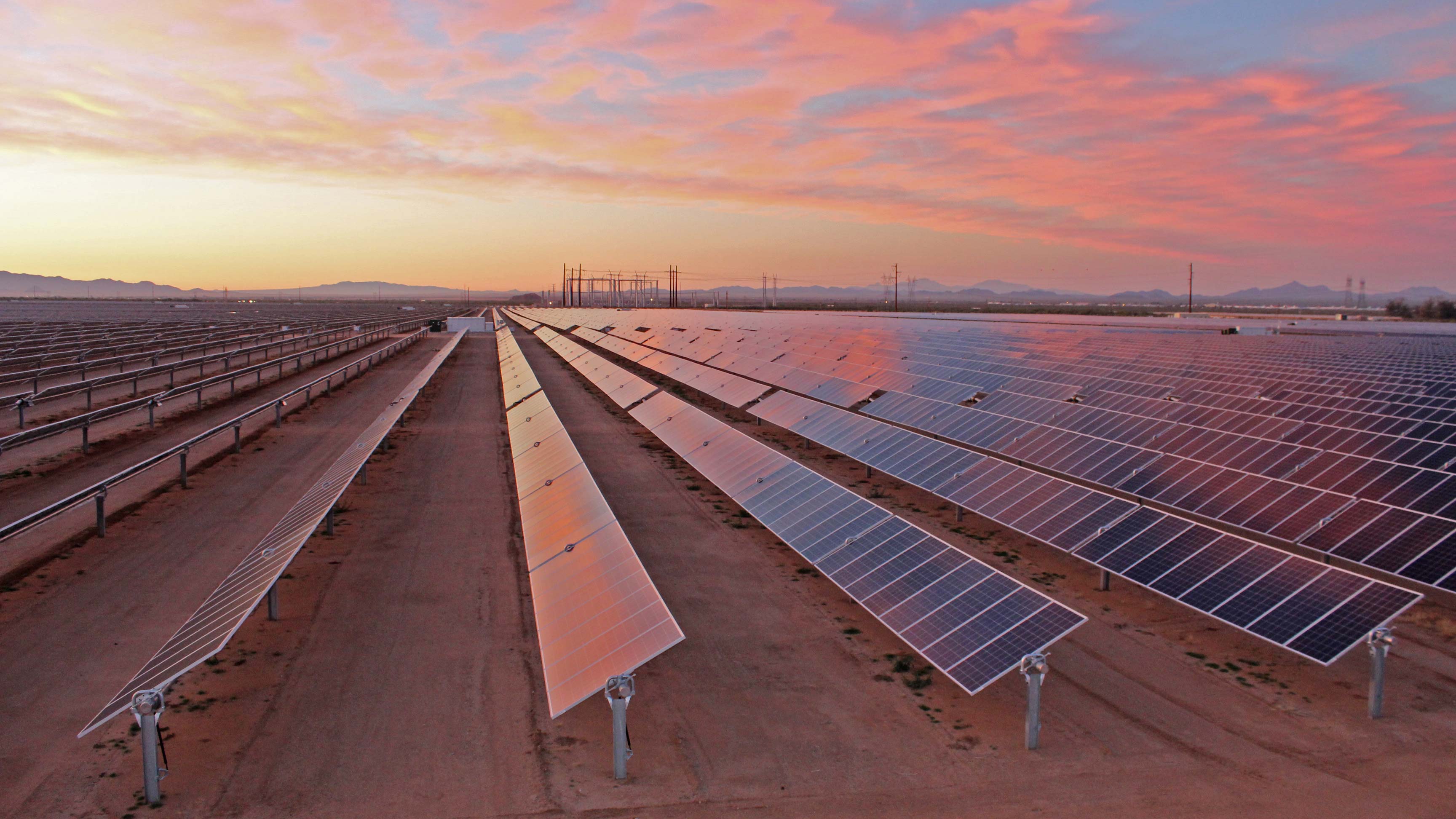 solar plant with sunset and mountain view in background