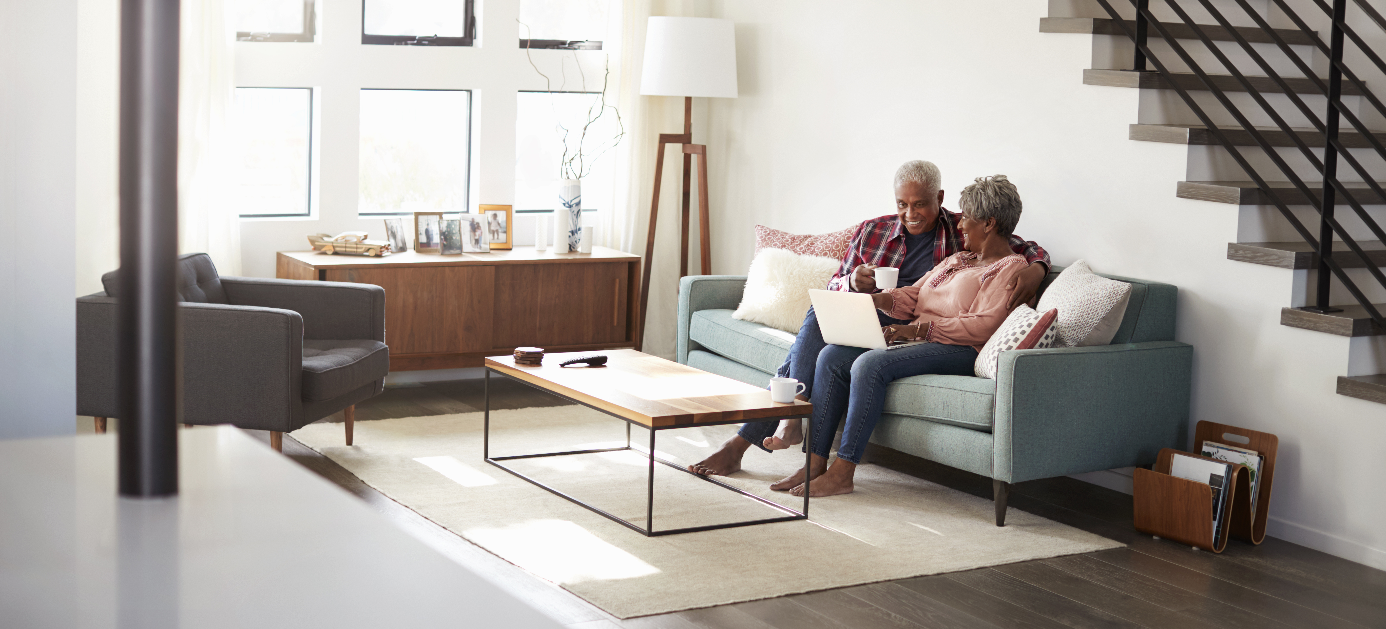 Man and woman sitting on couch in their house 