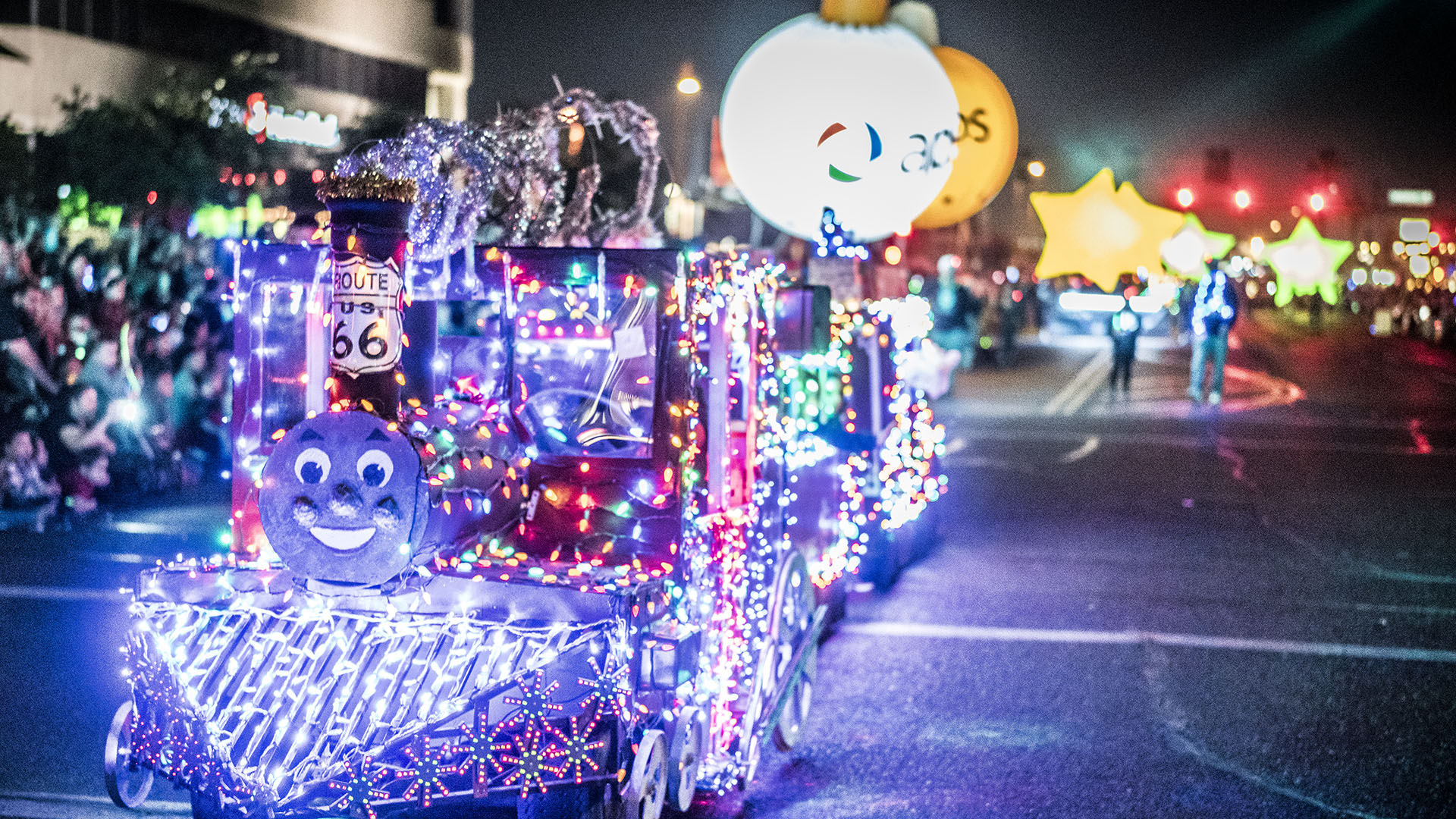 Parade at night with floats lighted bright with Christmas lights