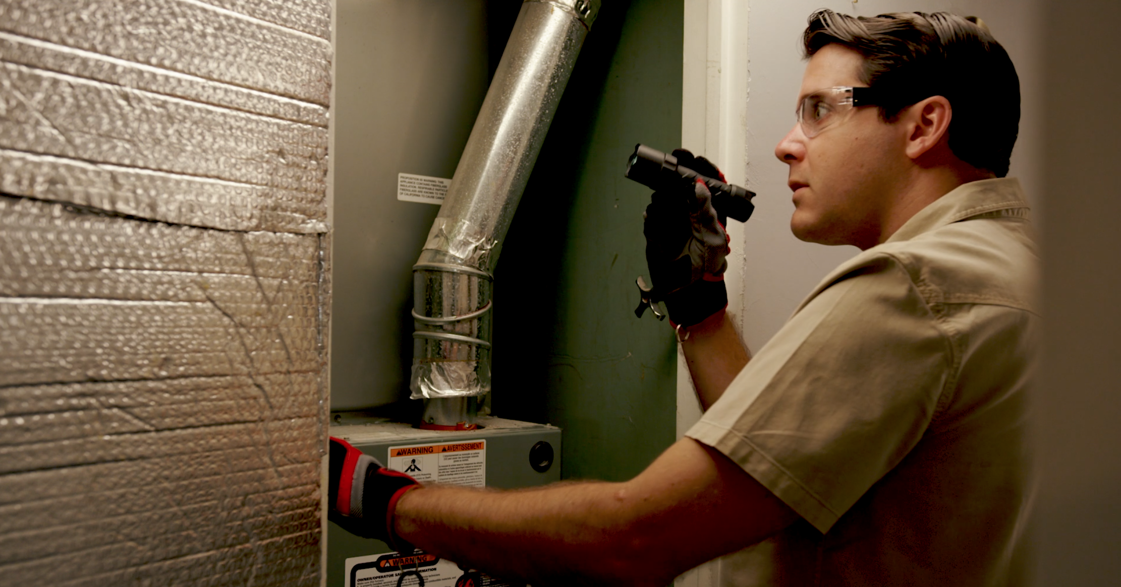 Serviceman inspecting air ducts inside a home