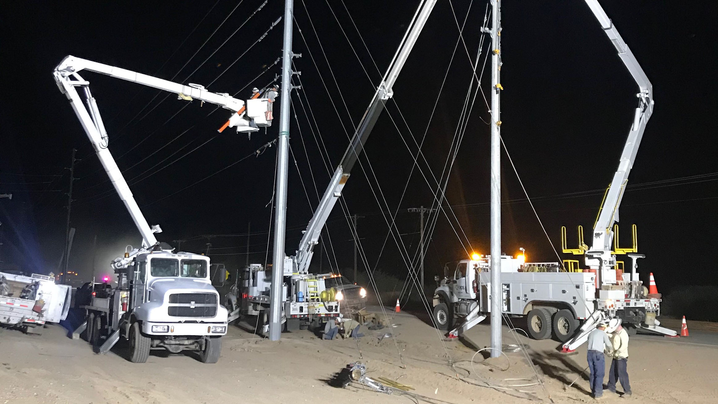 APS trucks and crew members working to repair damage from monsoon storms.