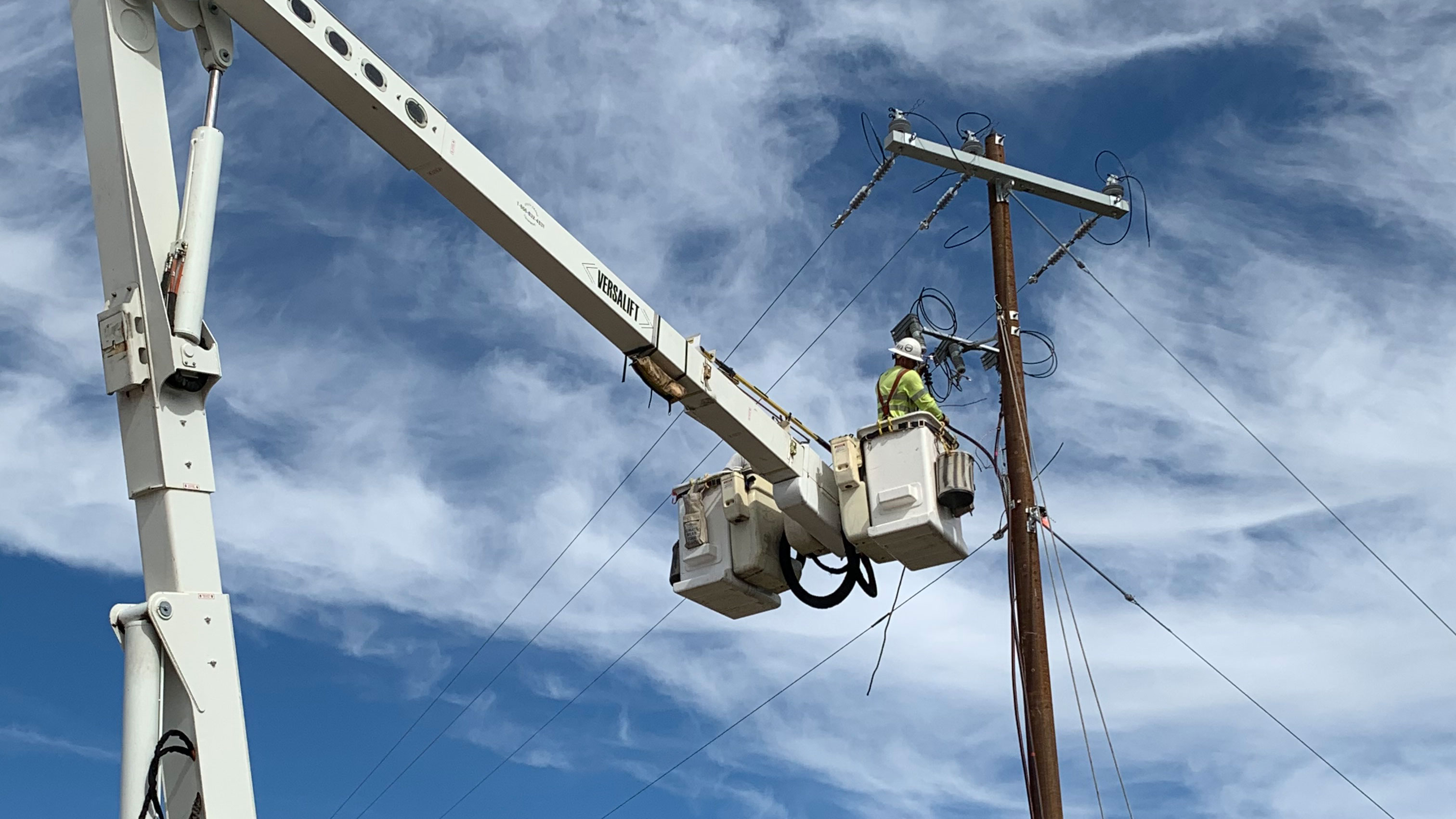 lineman in a bucket working on power lines