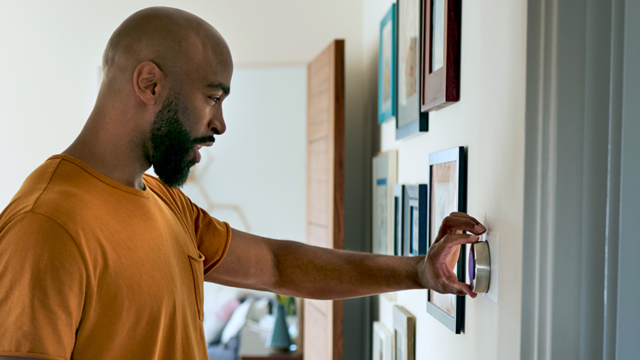 A man adjusting his thermostat