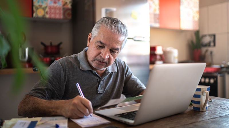 man paying bills on laptop