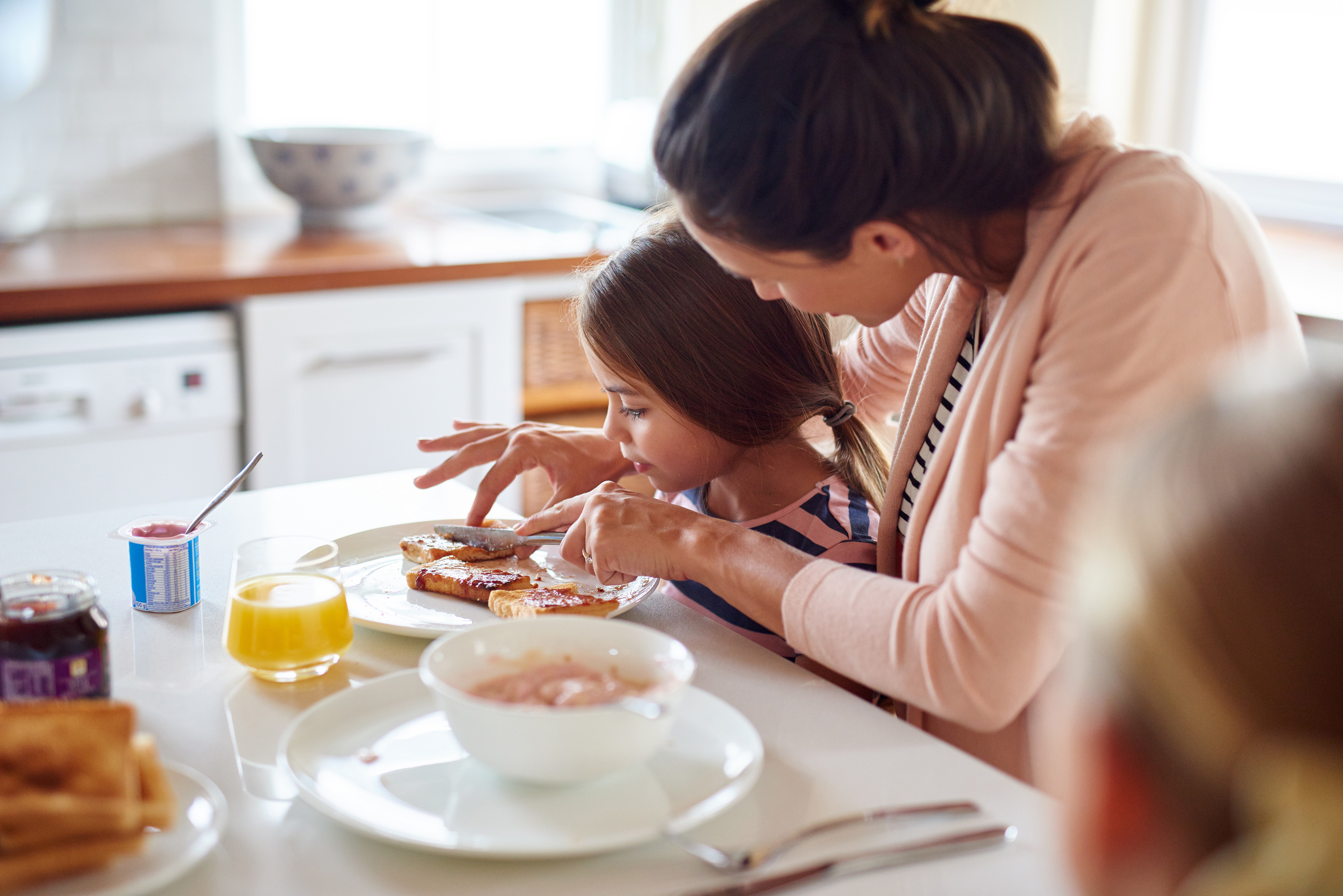 Madre e hija desayunando en la mesa