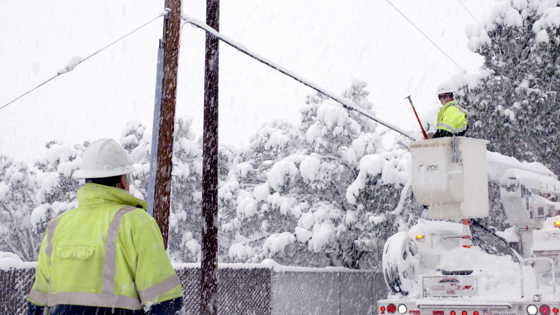 APS workers working on power lines in the snow