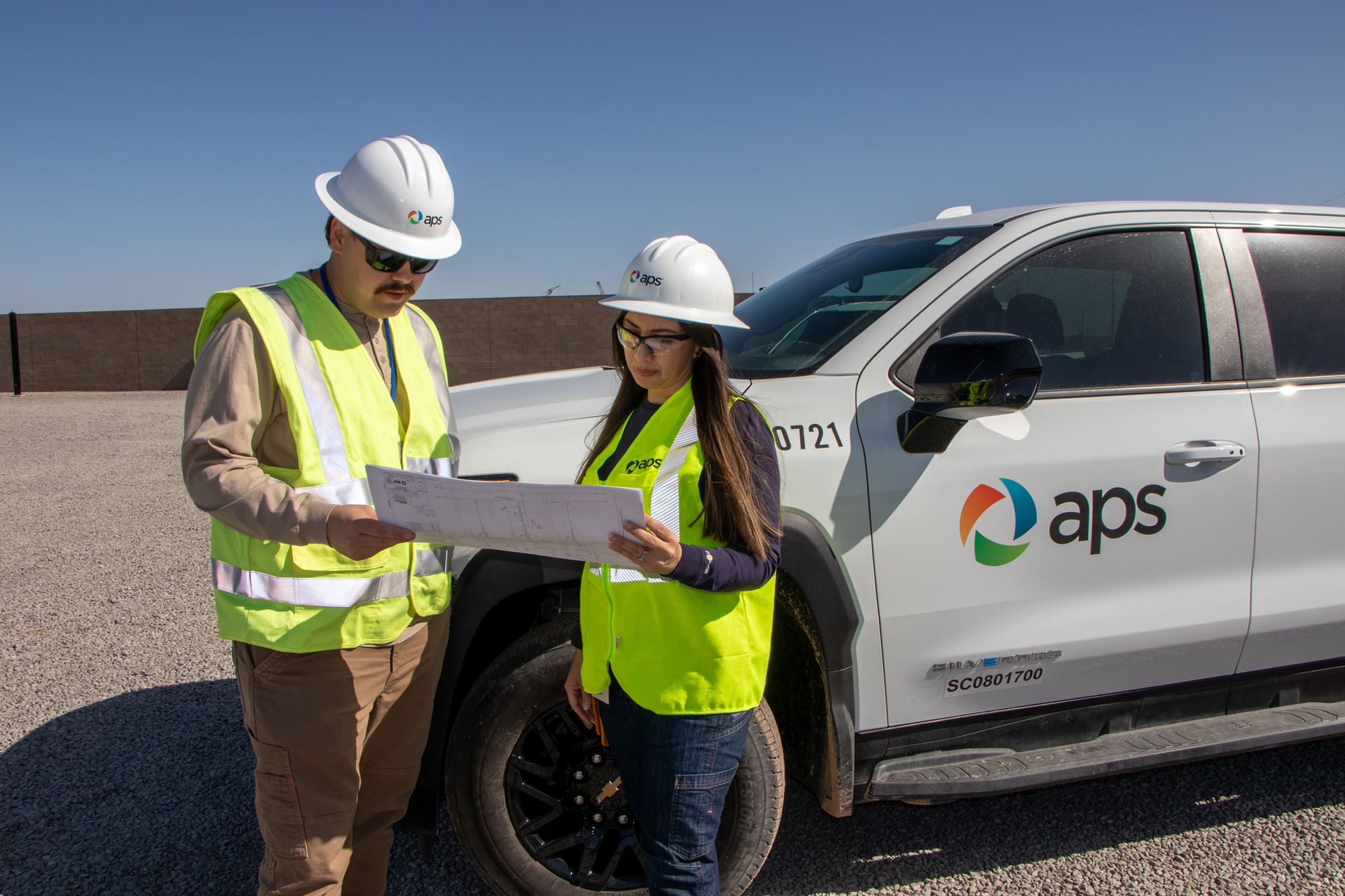 APS employees looking at blueprints