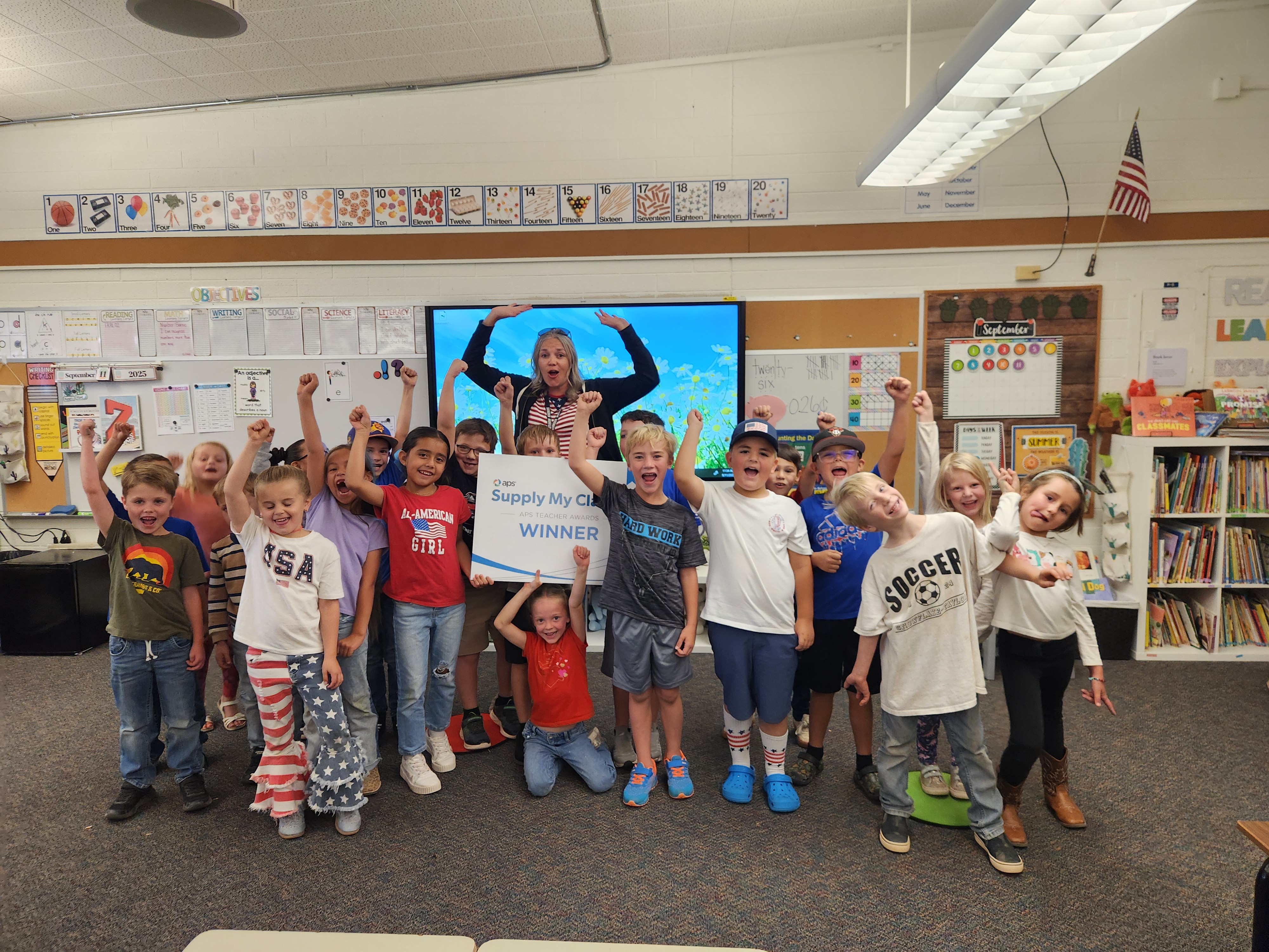 Ms. Ward, 1st grade teacher at Taylor Elementary School in Taylor, AZ, is surrounded by her students after the big surprise.