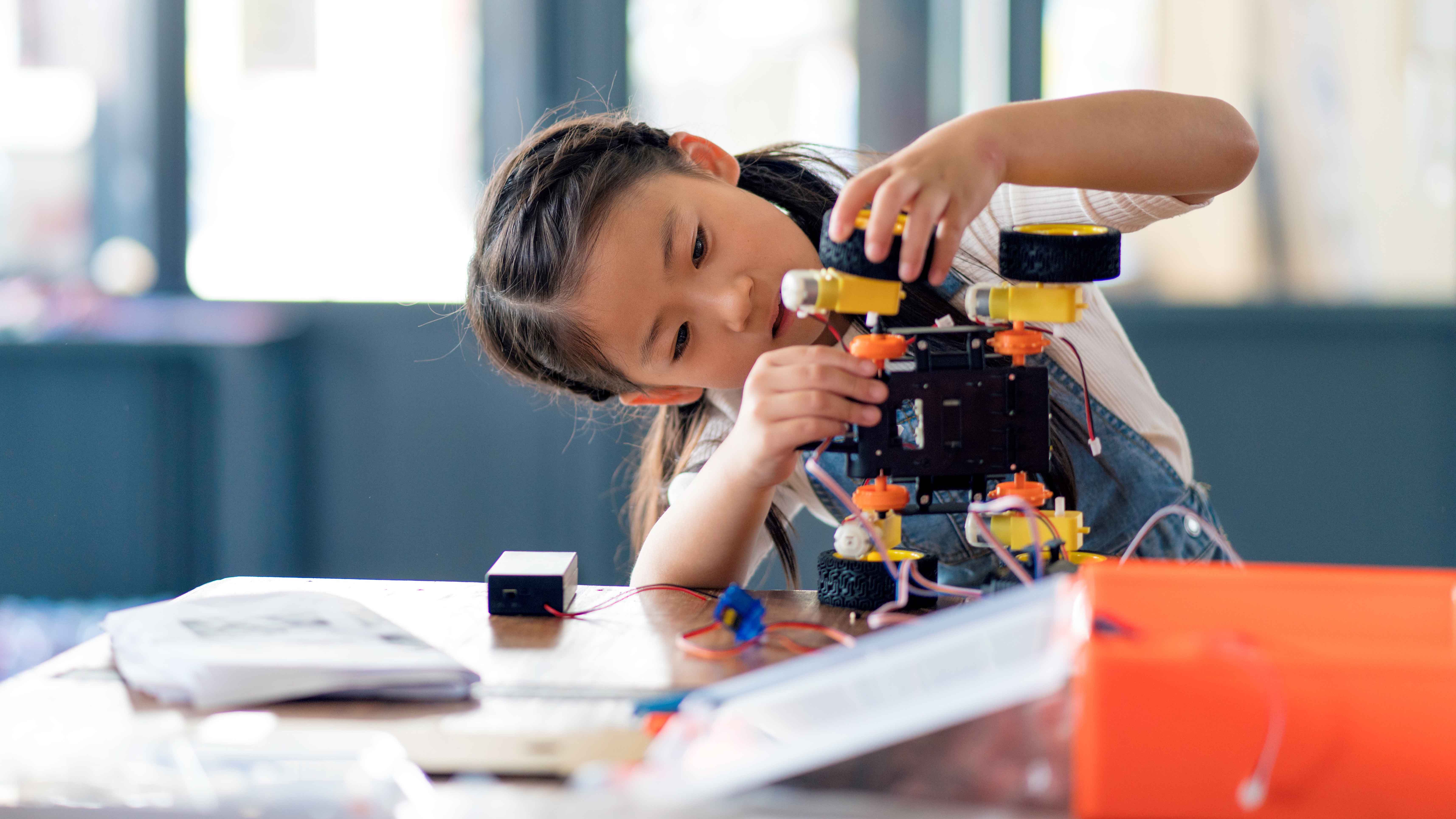 child student assemble robot