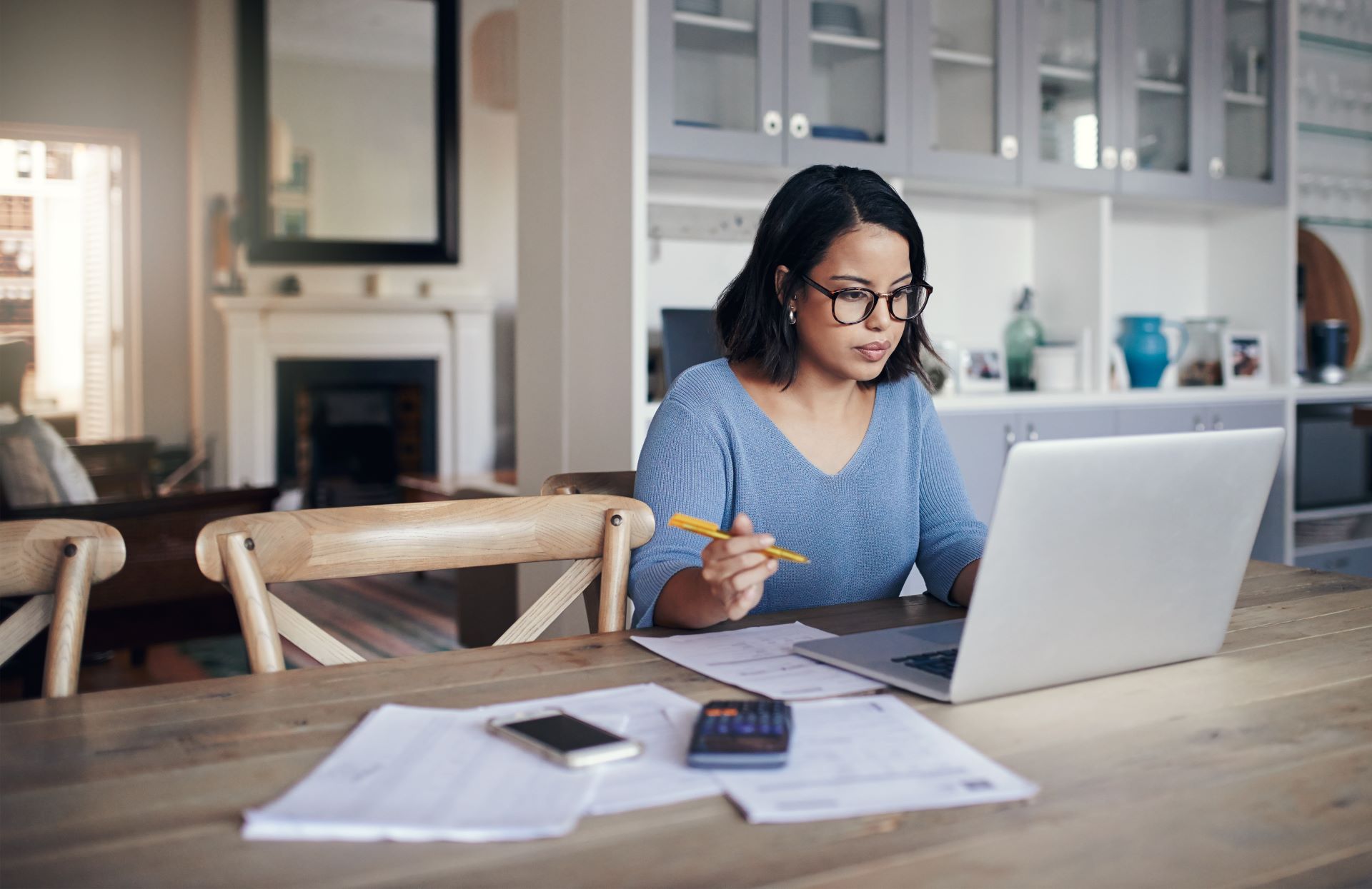 Woman working on a laptop at her kitchen table