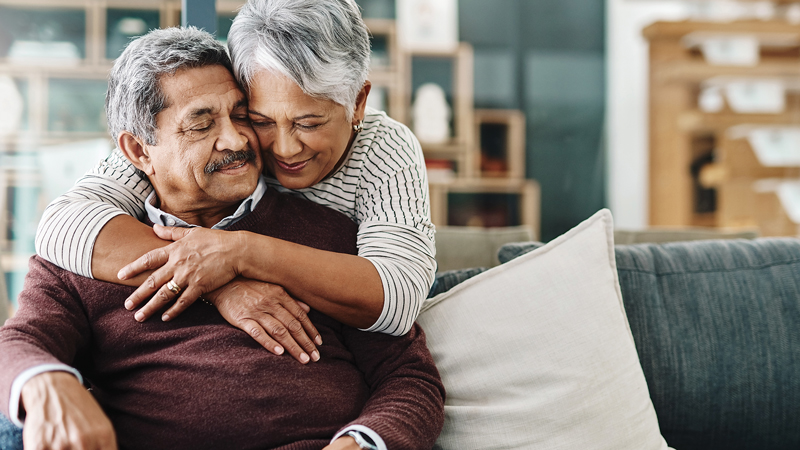 Couple hugs on couch