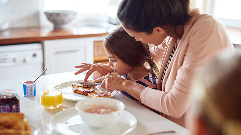 Mother and daughter having breakfast at a table