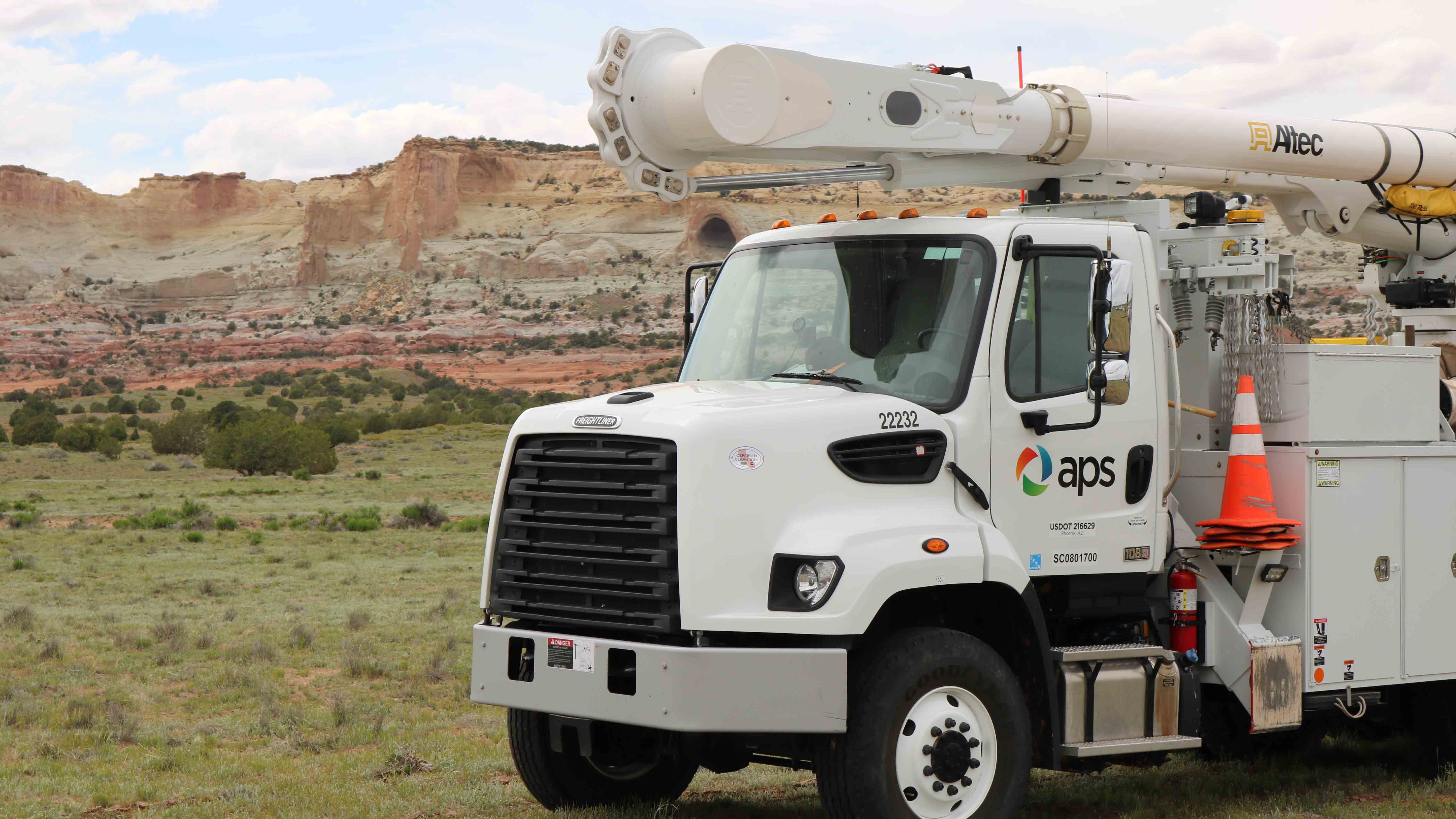 APS bucket truck parked in field 