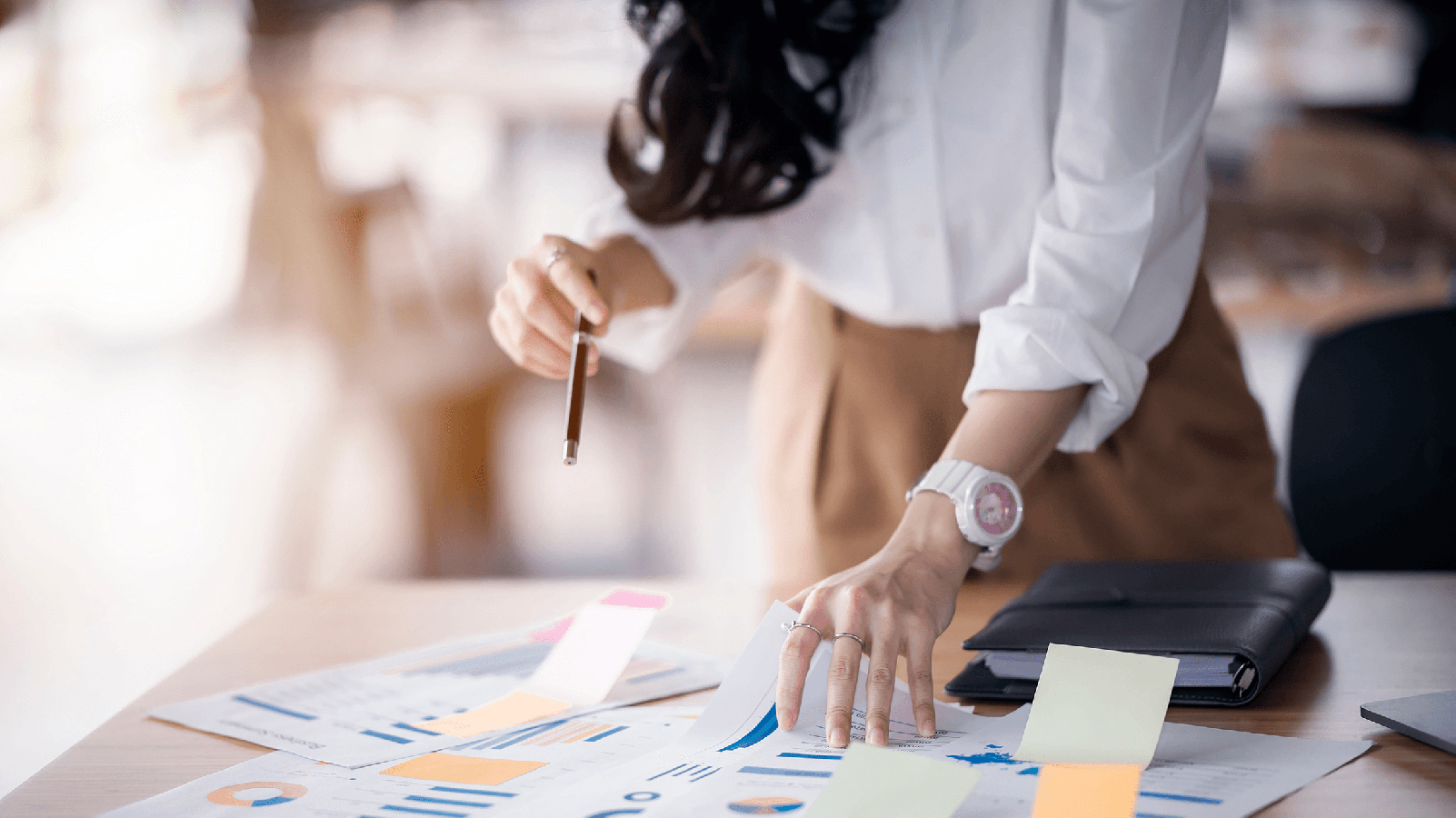 Woman looking at paperwork on a desk.