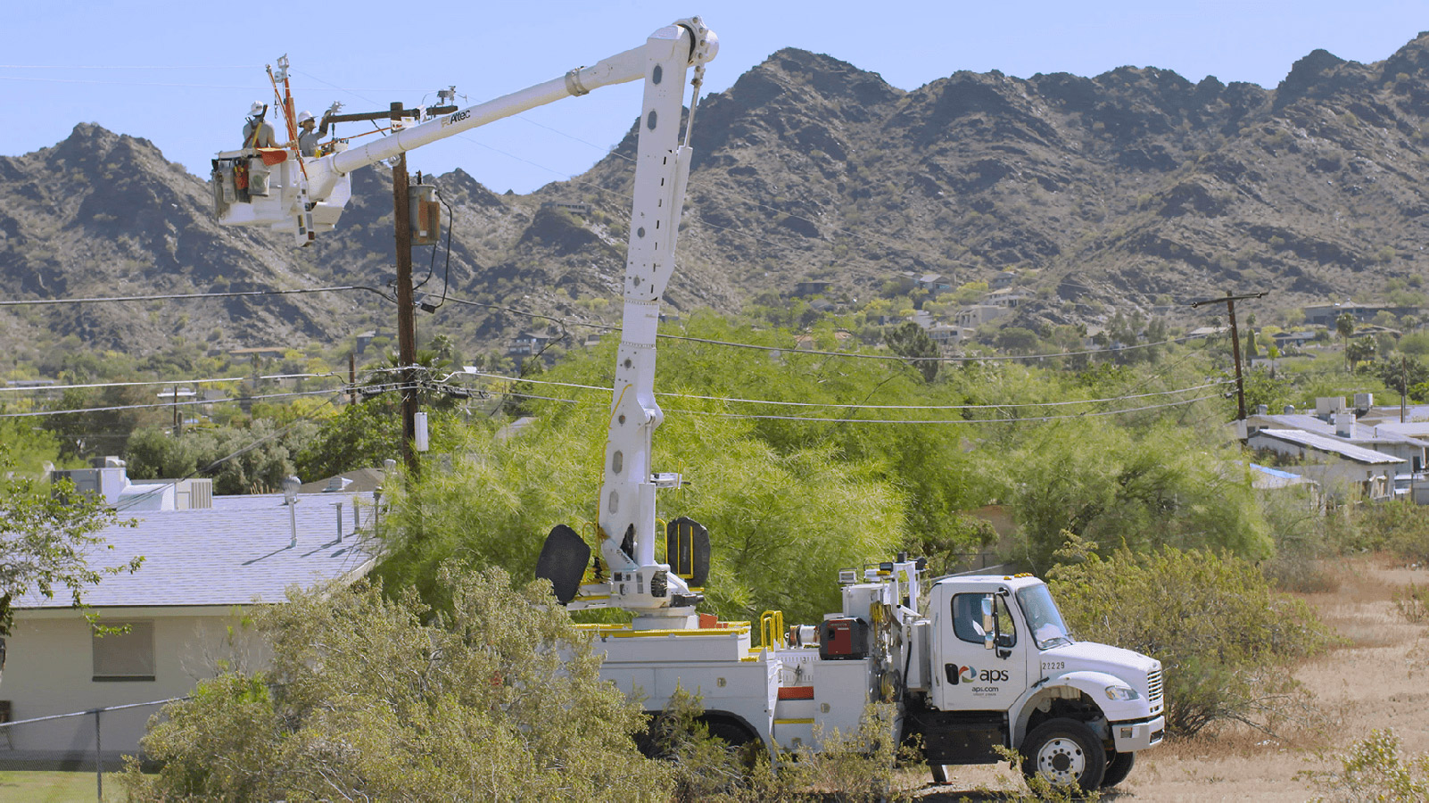 APS truck near a home and power lines.