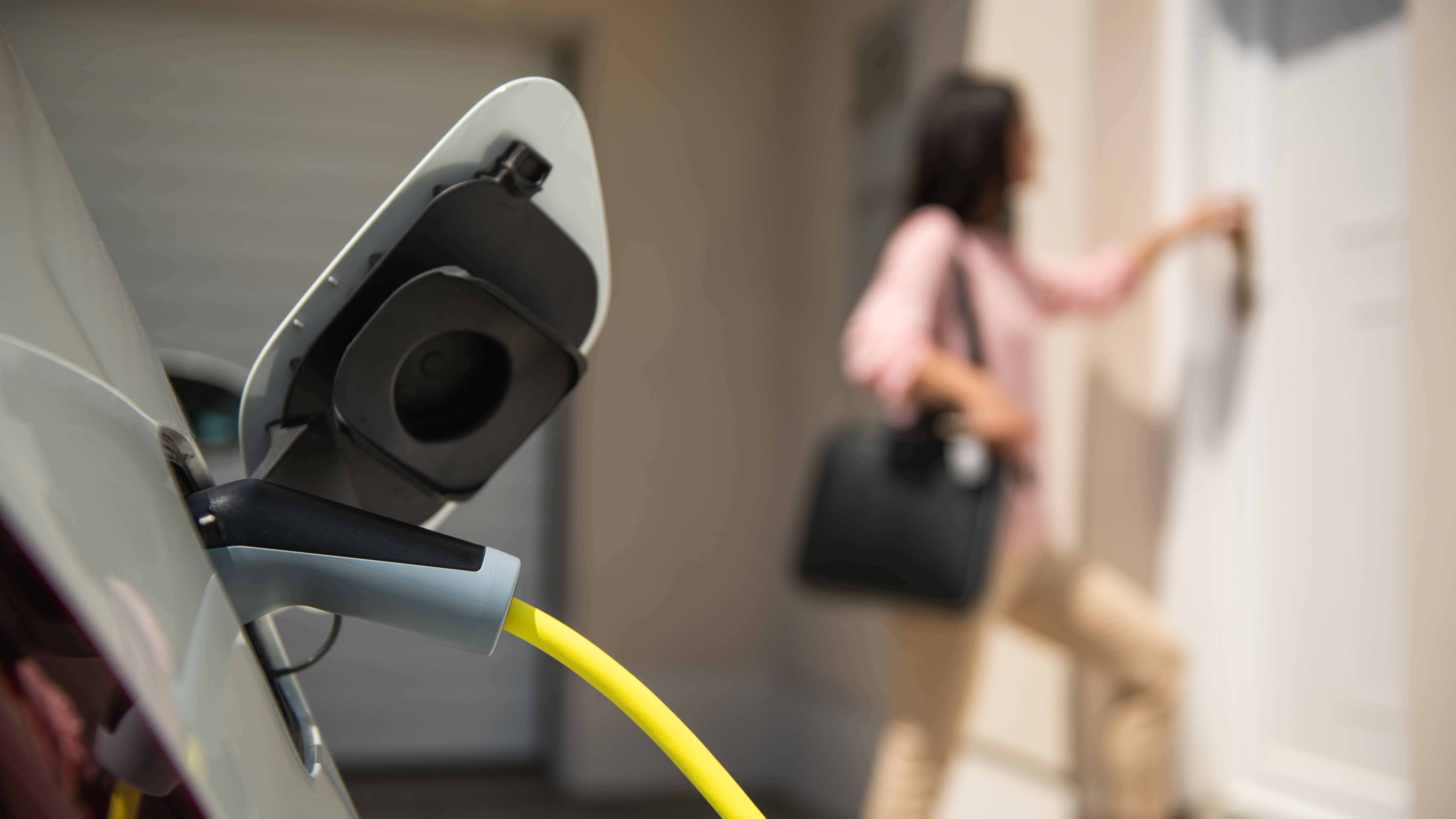 close up view of an EV charge port with woman in foreground 