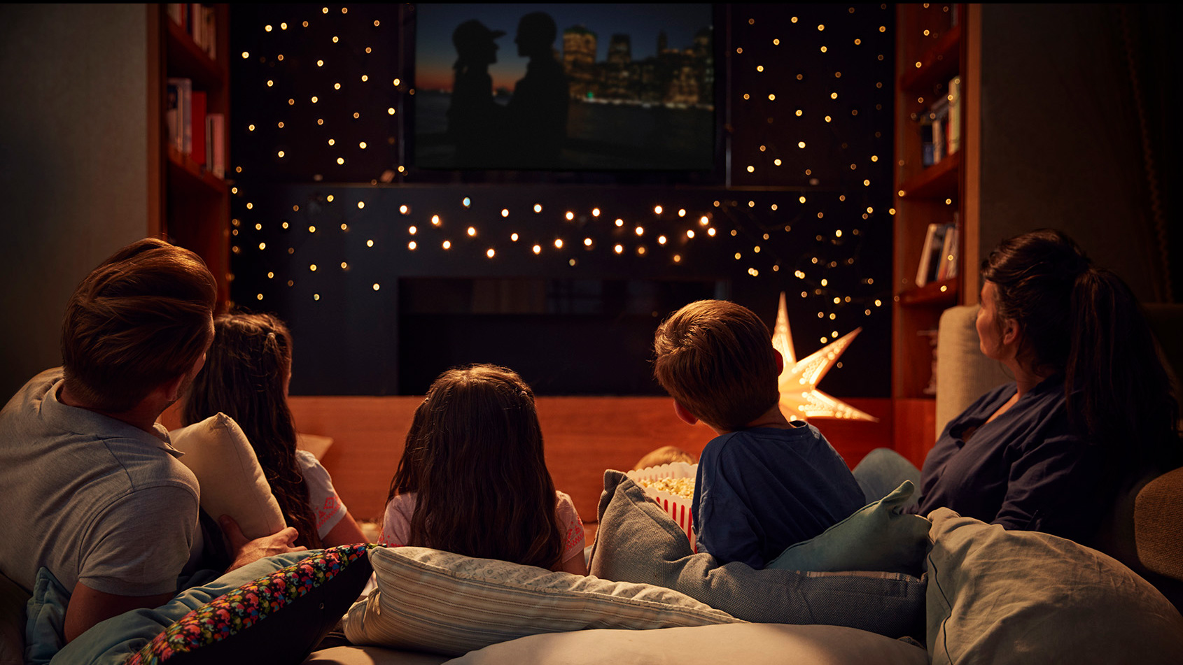 Family in living room watching a movie.