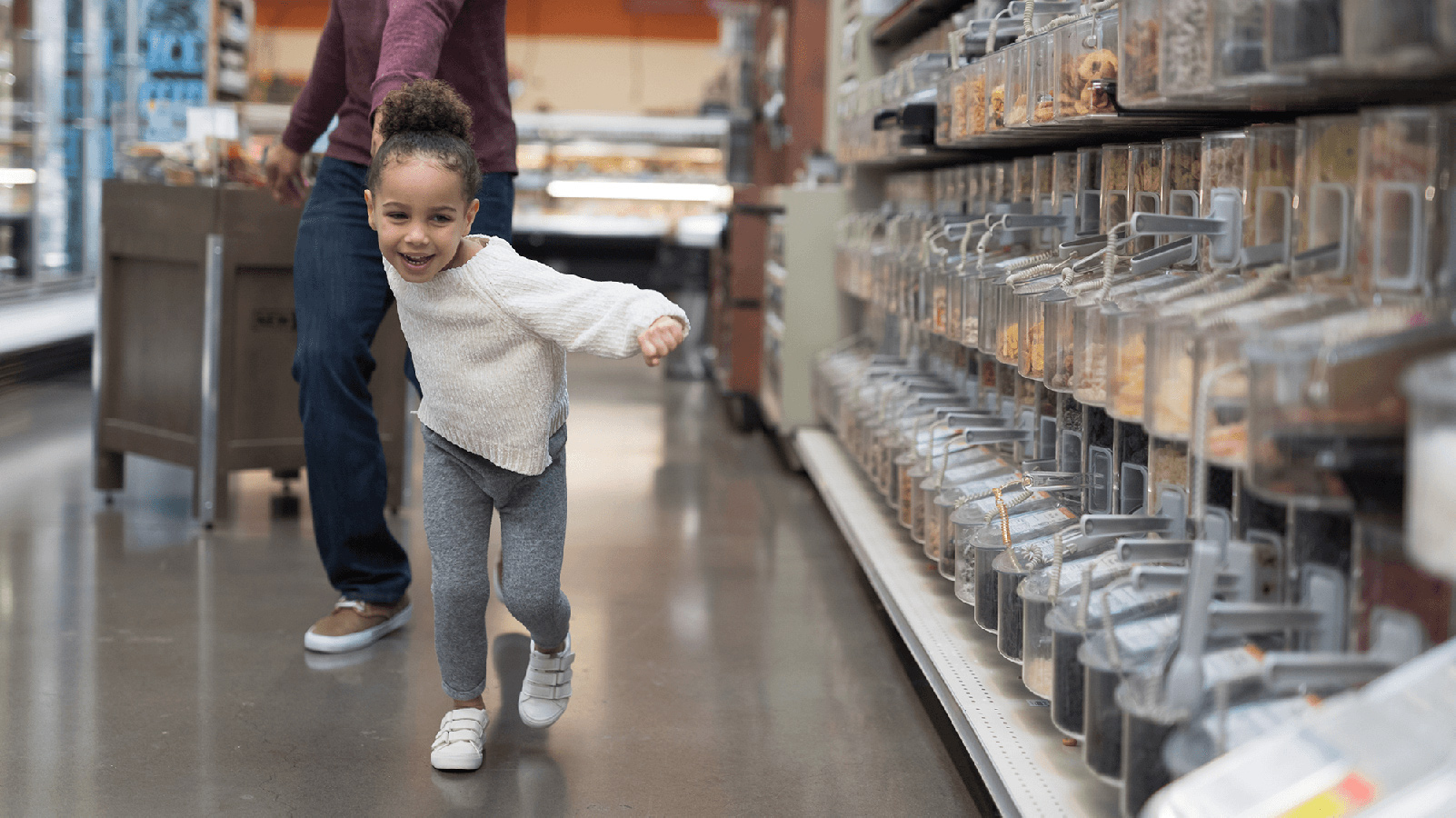 Little girl pulling her dad through a grocery store.