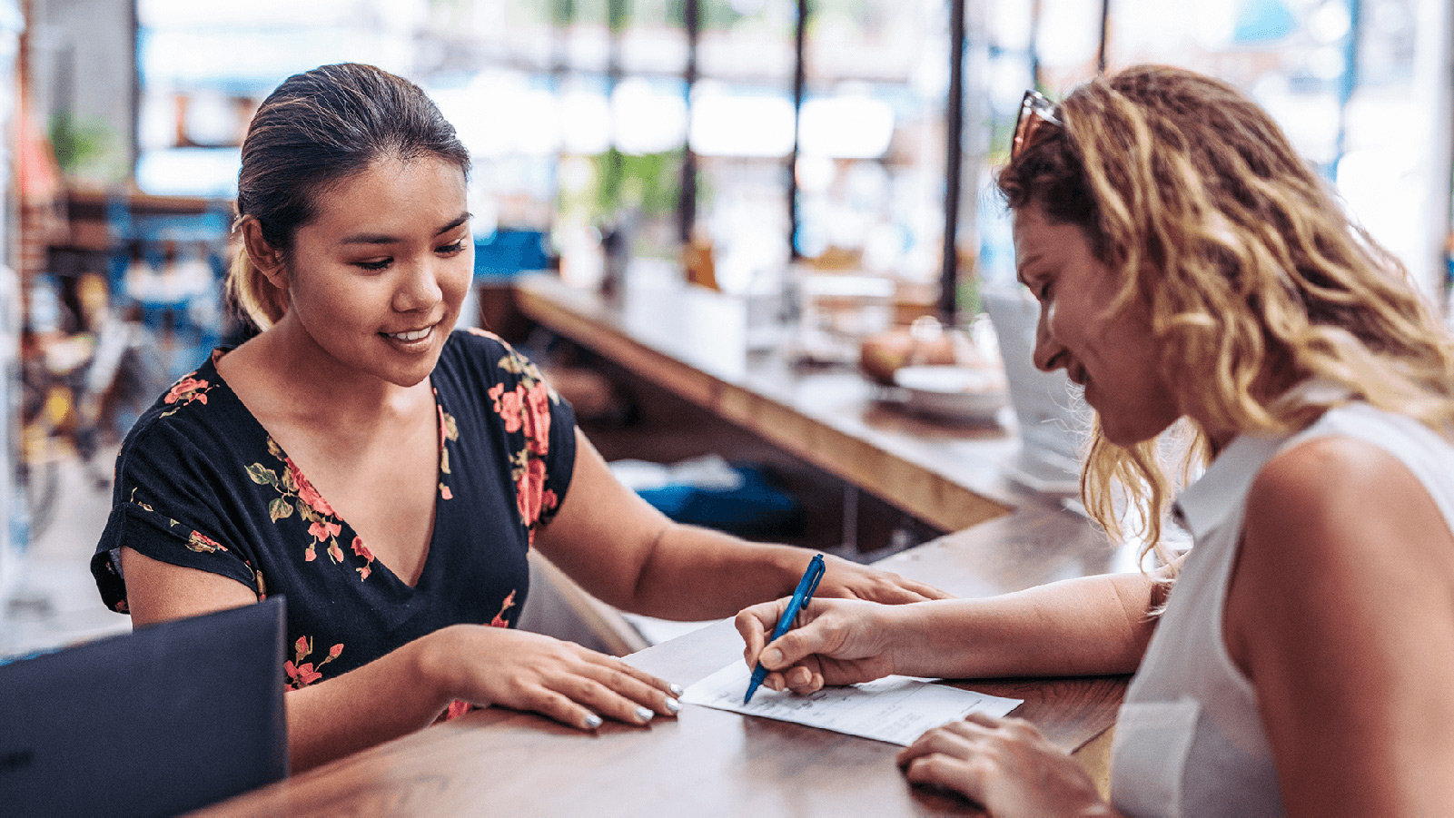 Two women reading over a list together.