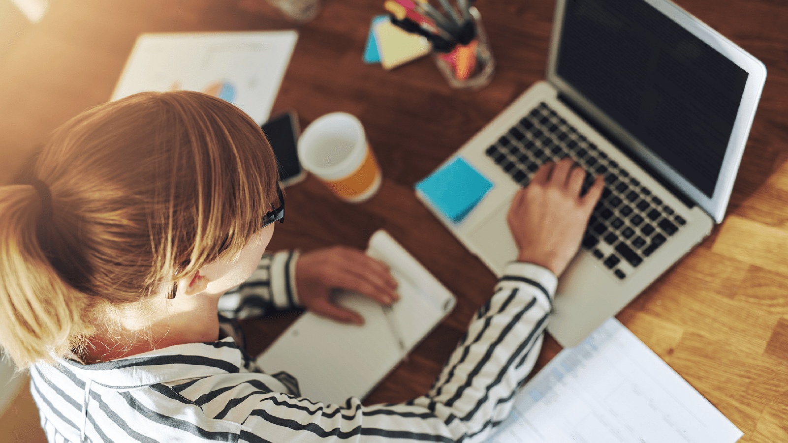 Young professional working on her laptop at her desk.