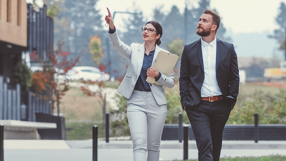 Two professionals walking and pointing