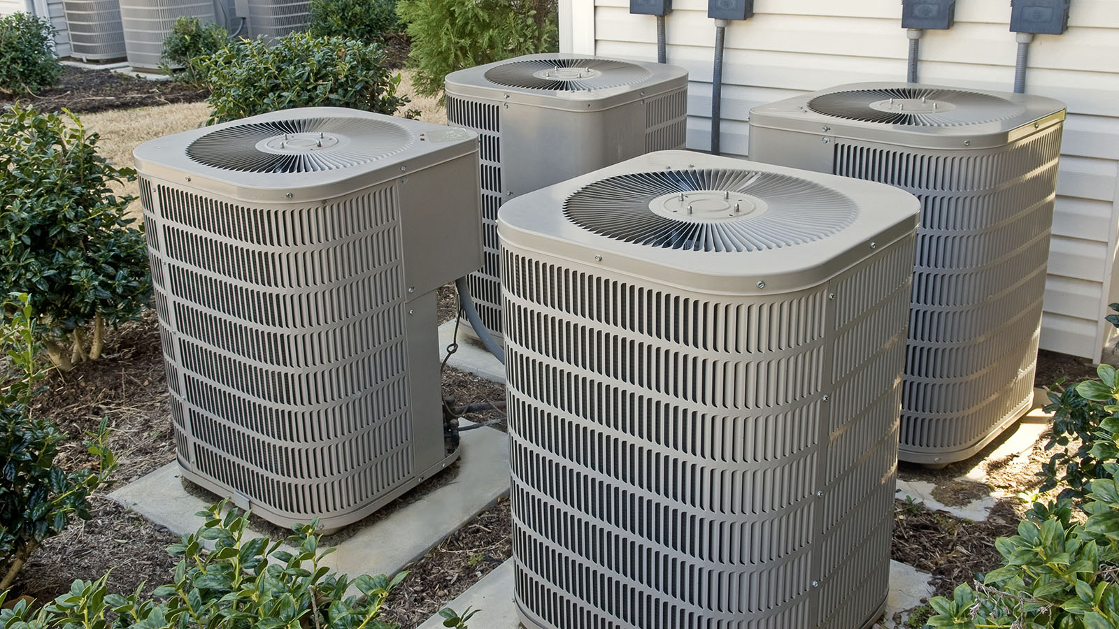 A side yard with four a/c units.