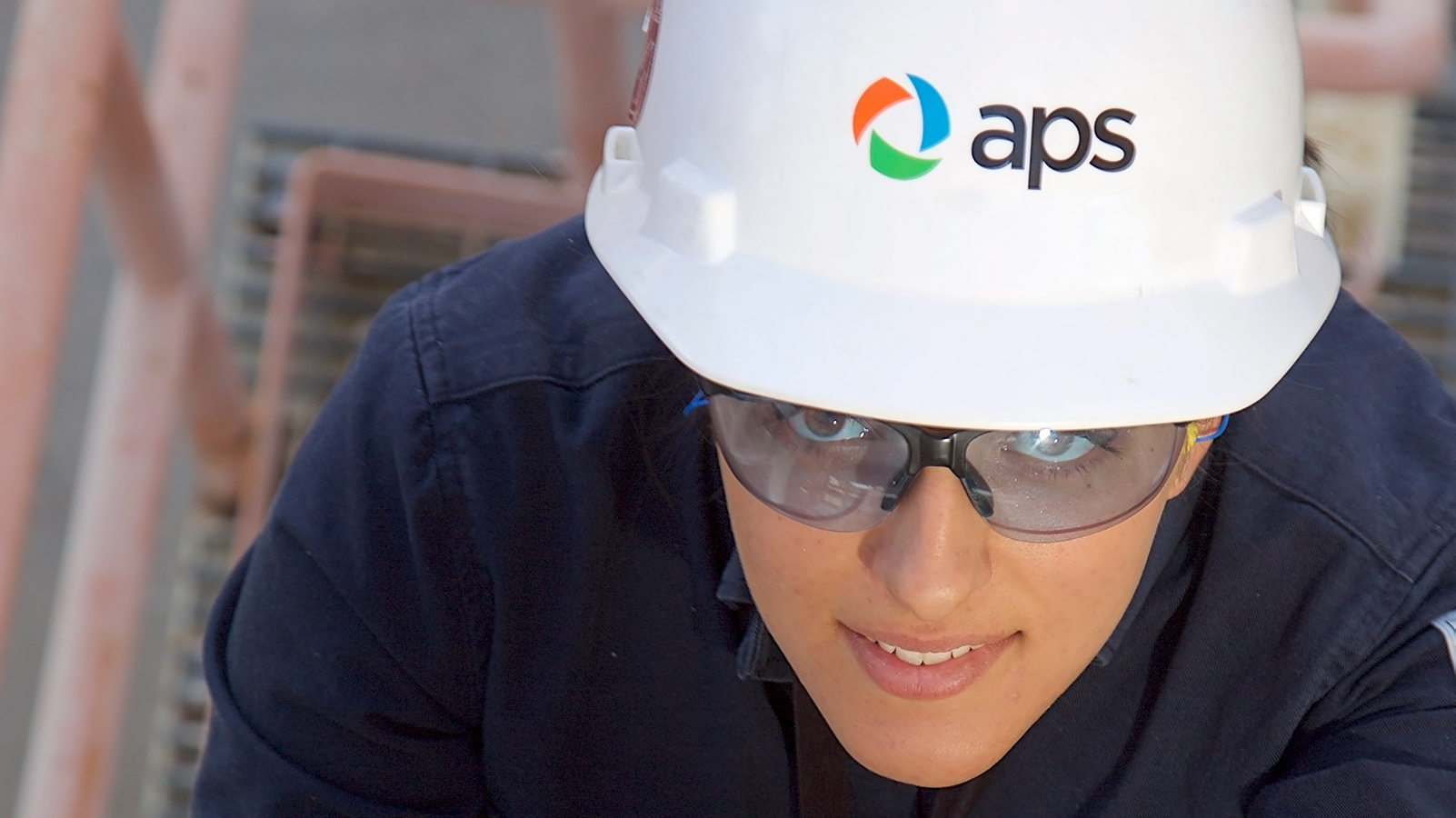 APS employee climbing a ladder.