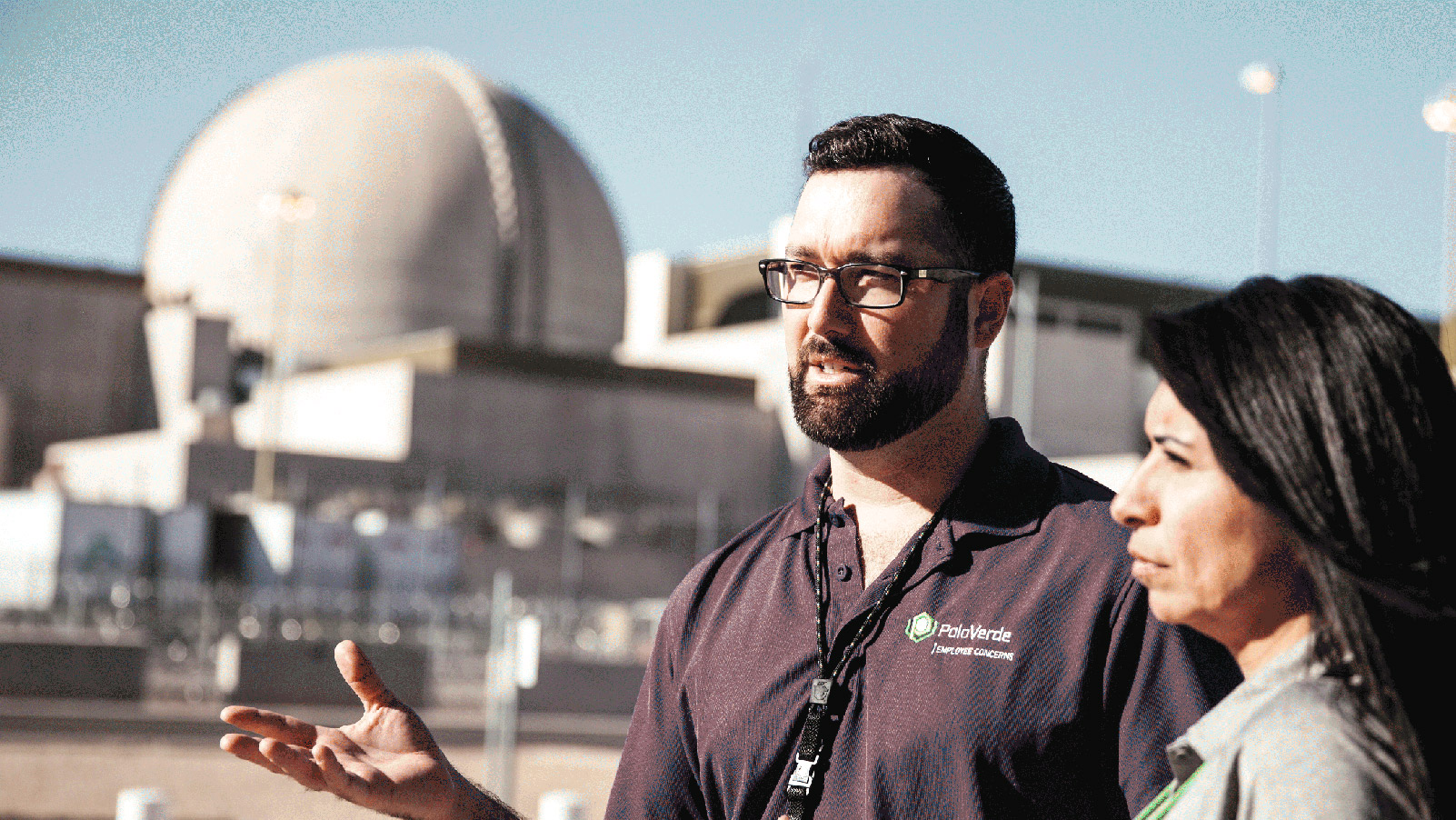 Two APS employees talking in front of a Palo Verde containment structure.