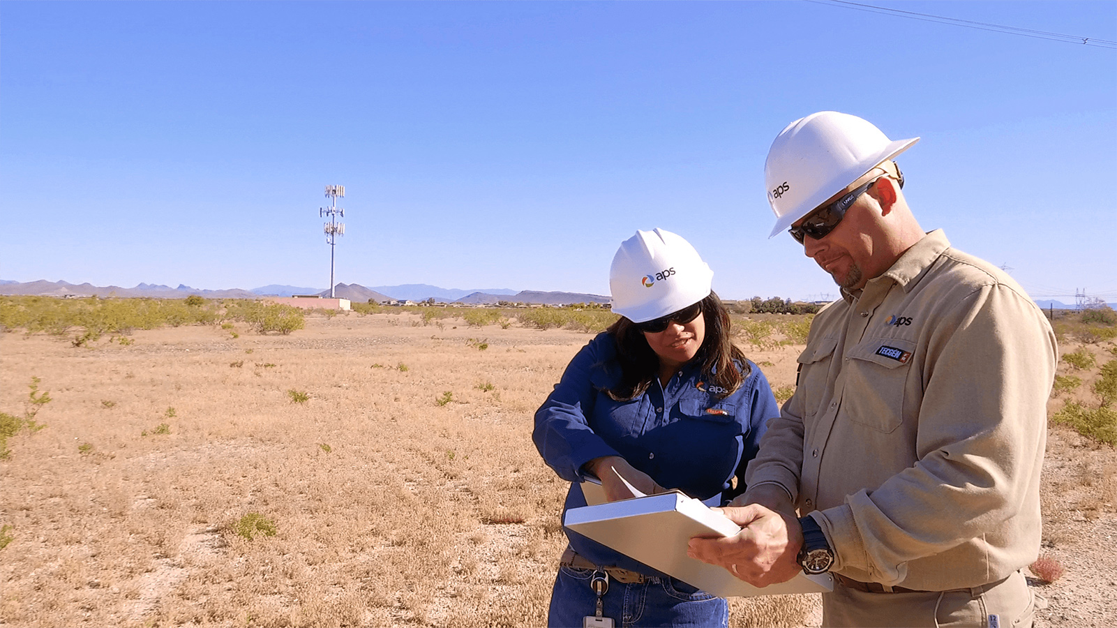 Two APS employees looking at paperwork.
