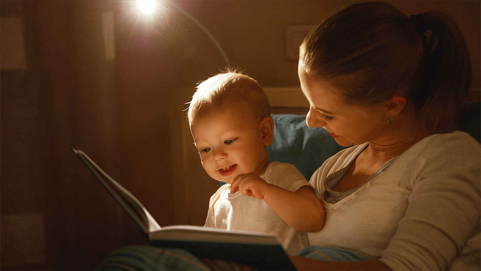 Mother reading a book to her baby.