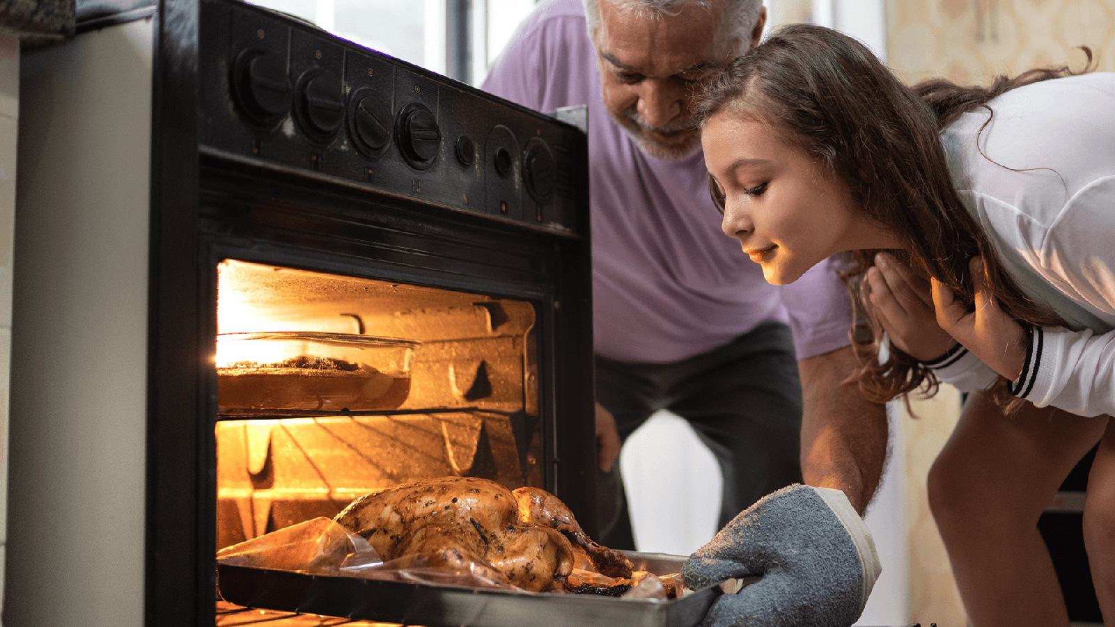 Father and his daughter cooking a turkey.