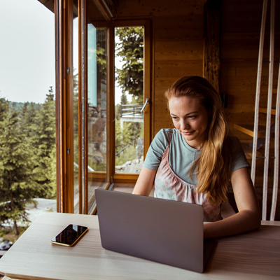 Woman on laptop at cabin
