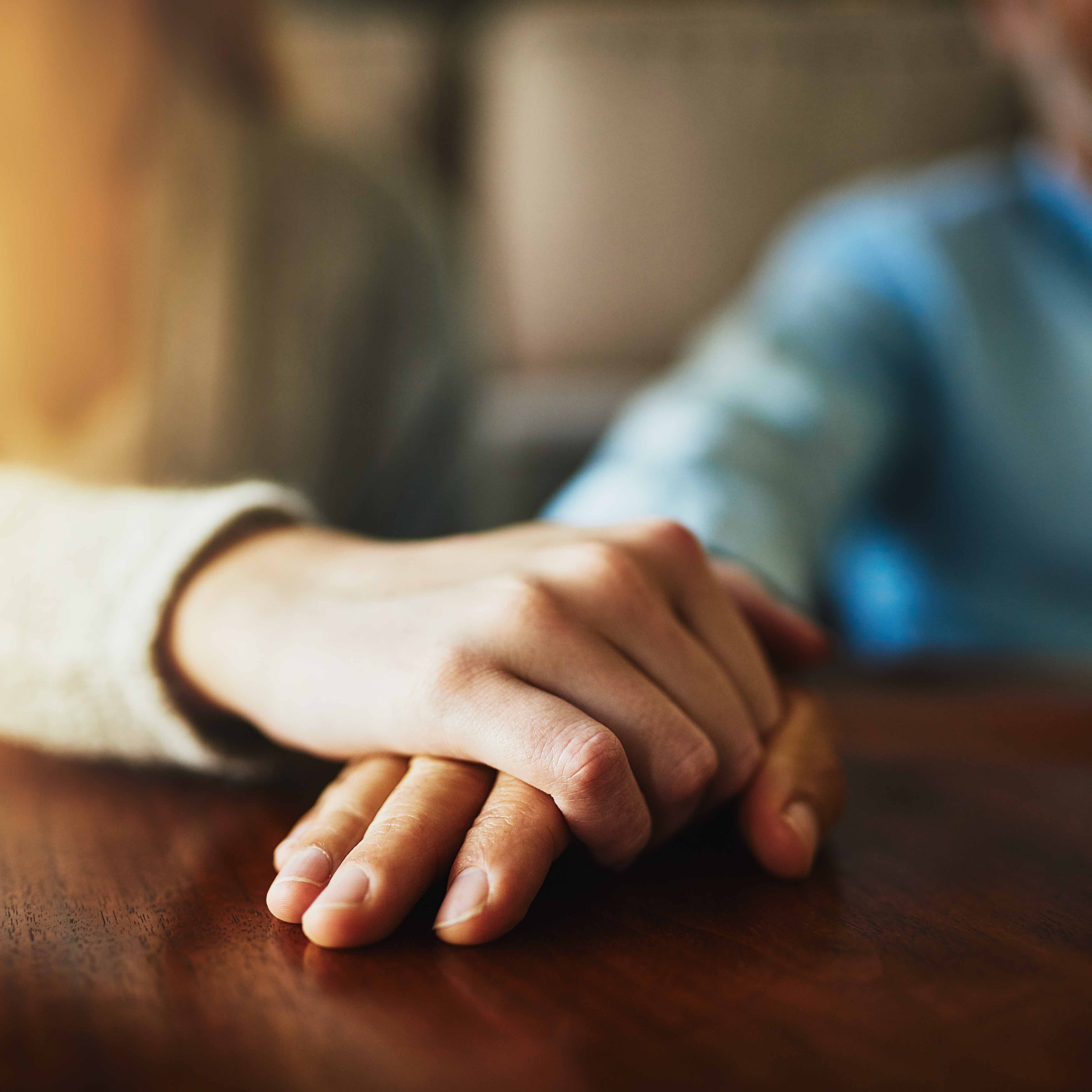 close up view of two people holding hands 