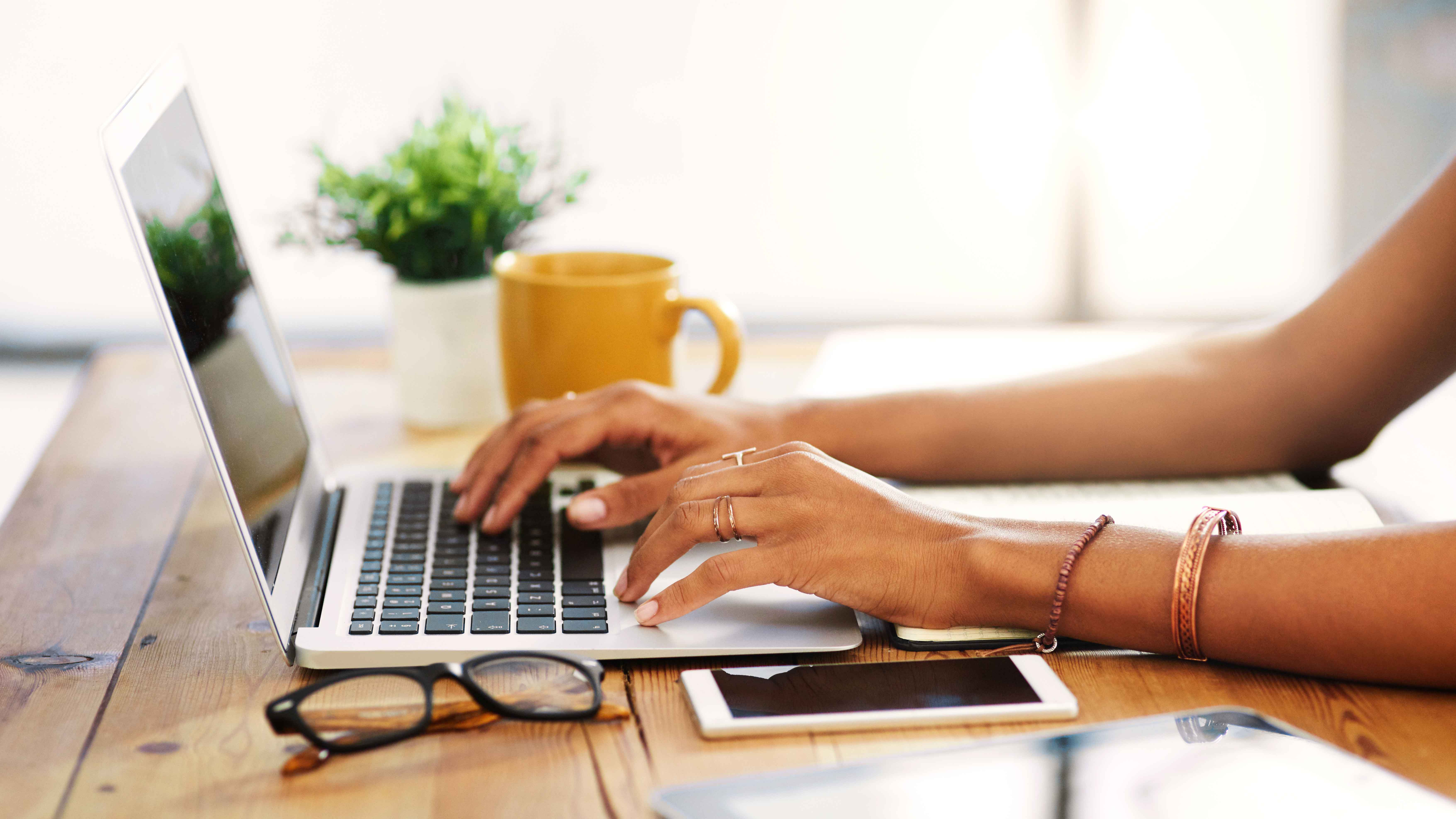 woman's hands typing on a laptop