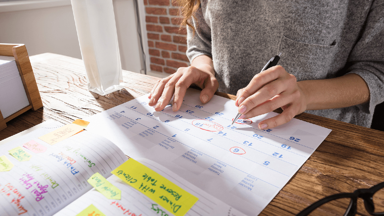 Woman marking dates on a calendar.