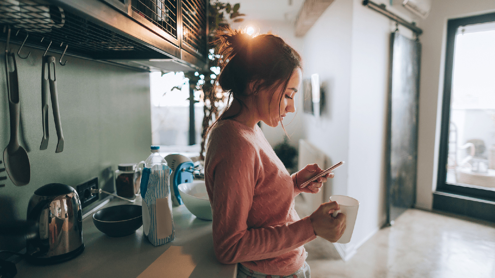 Woman using her phone while having coffee.