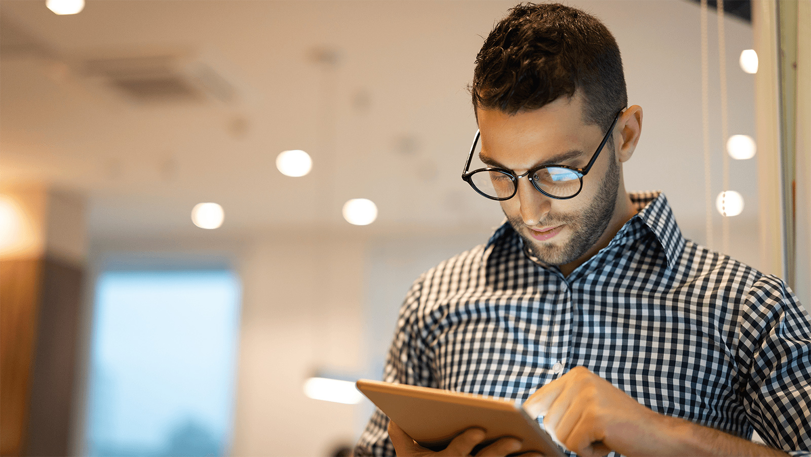 Man in glasses using his tablet.