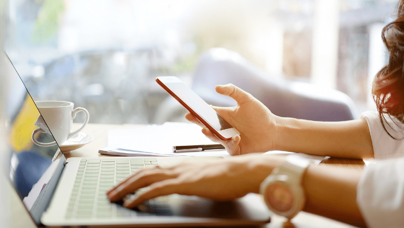 Woman working on her laptop and phone.